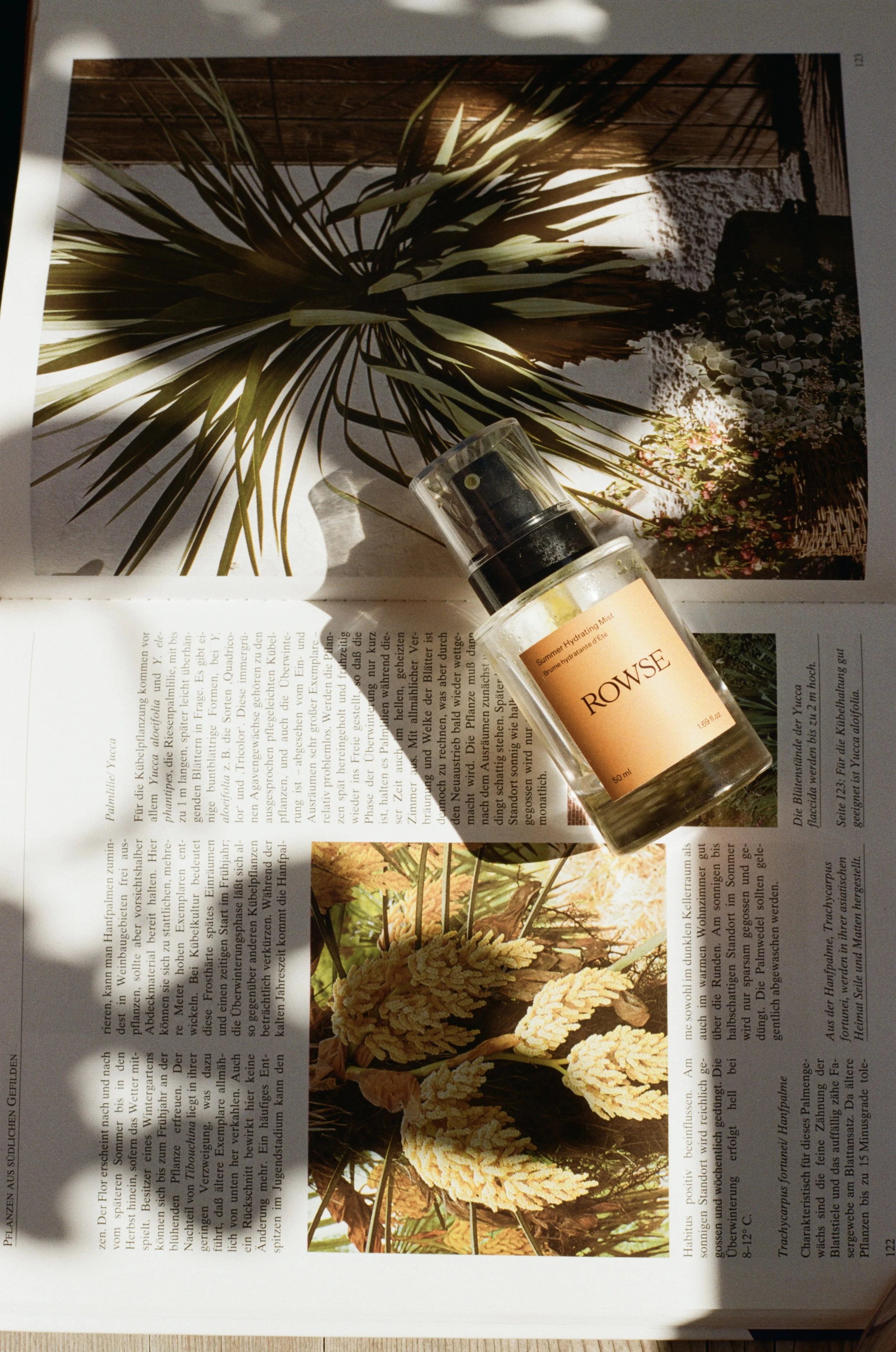 A magazine page with sun and plant photographs and a bottle of Rowse hydrating mist.