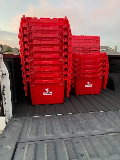 Uniformly stacked reusable moving containers in a truck bed, showcasing how moving plastic bins save space and stay secure during complimentary delivery / transit.