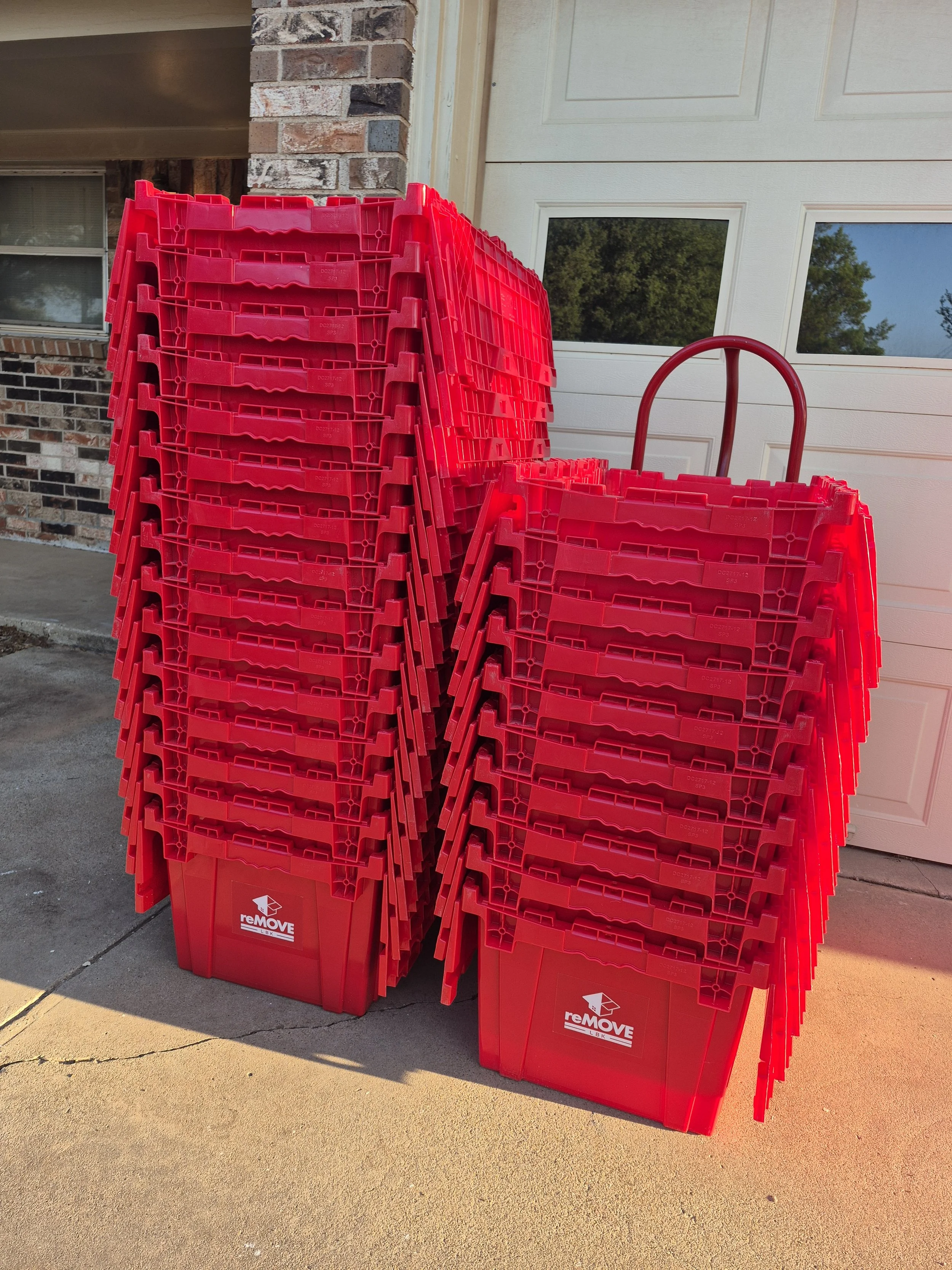 High-quality plastic moving bins arranged for a residential move, demonstrating the uniform size and stackability of reusable moving boxes in Lubbock Texas.