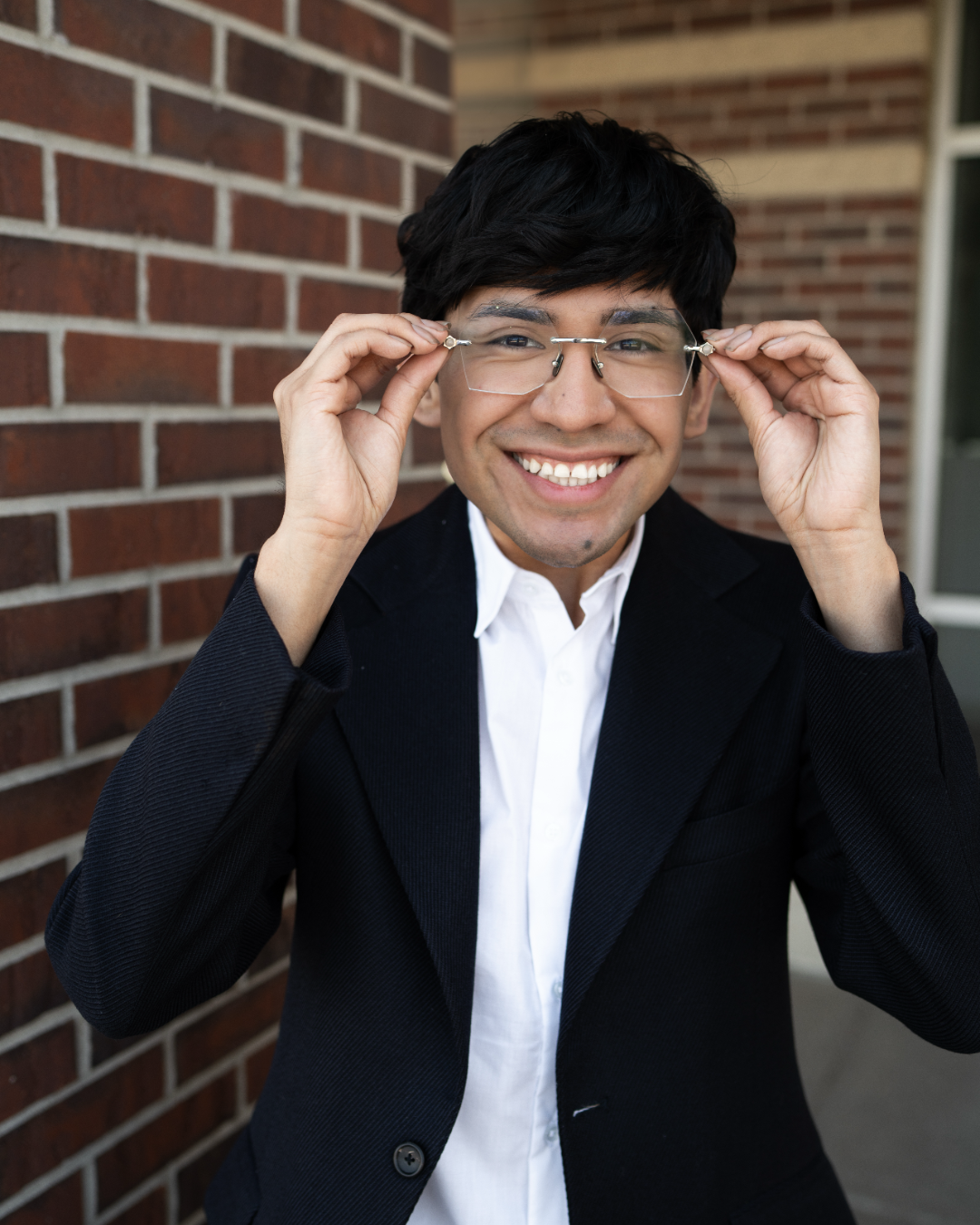 Photo of male stylist in Elkhorn Nebraska holding his glasses