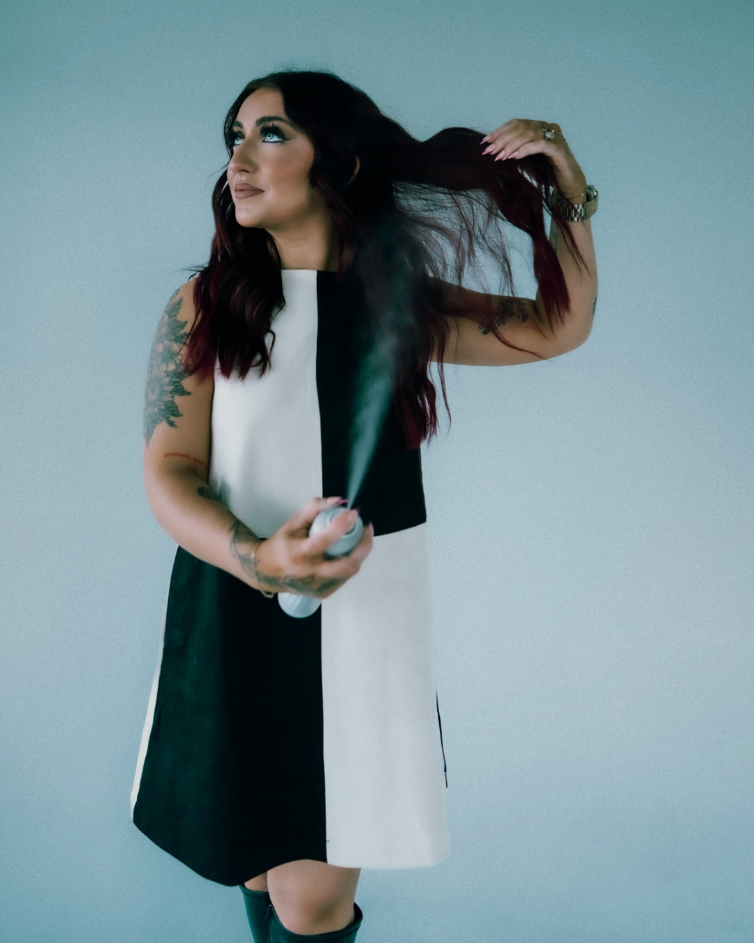 Independent stylist at an Elkhorn, Nebraska salon smiling confidently, showcasing soft, dimensional blonde hair. Specializes in customized color and hair loss solutions as part of the expert stylist team.