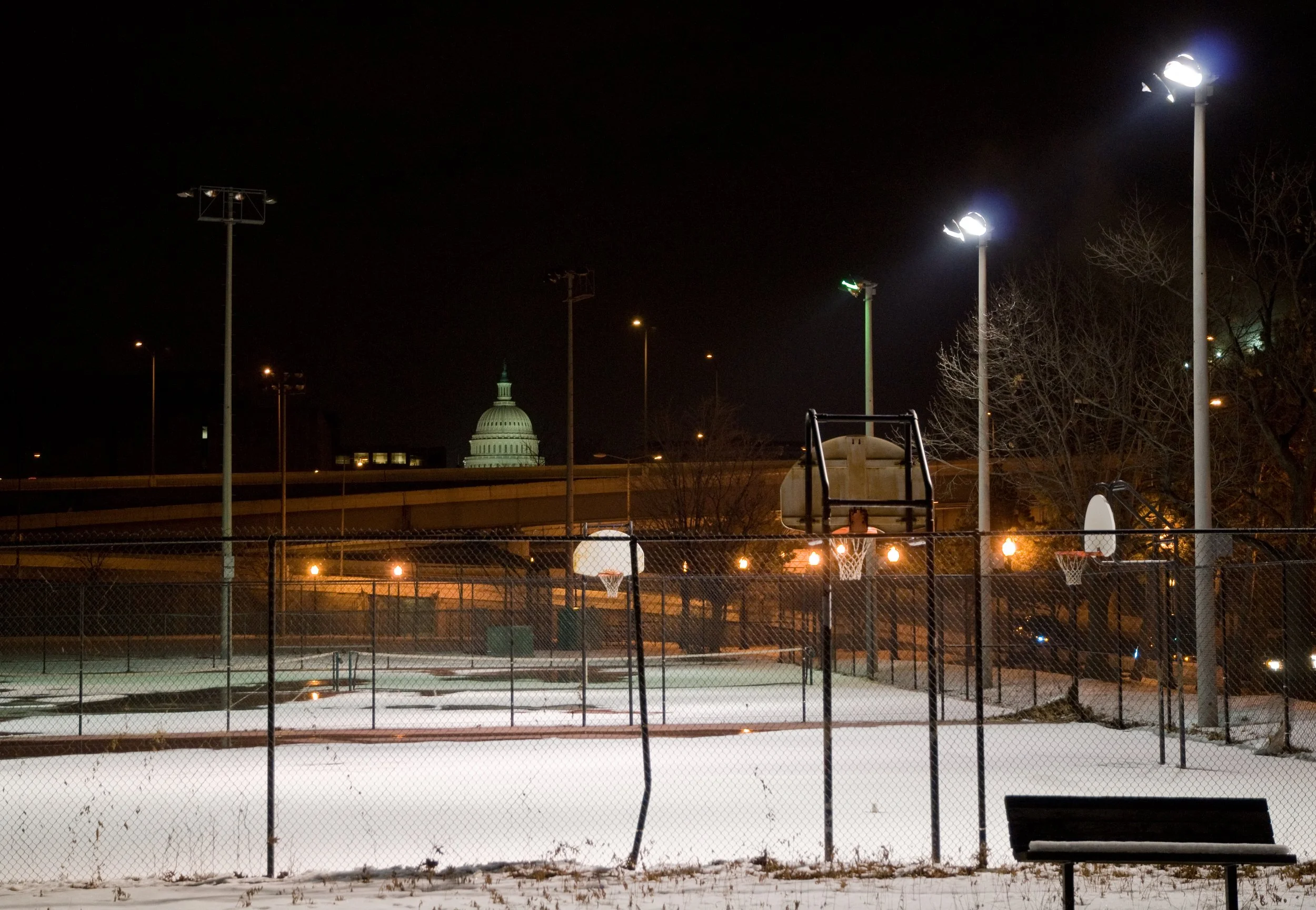 (Photo: Outdoor athletic courts in Washington DC that are illuminated by spotlights even when covered in snow during the wintertime)