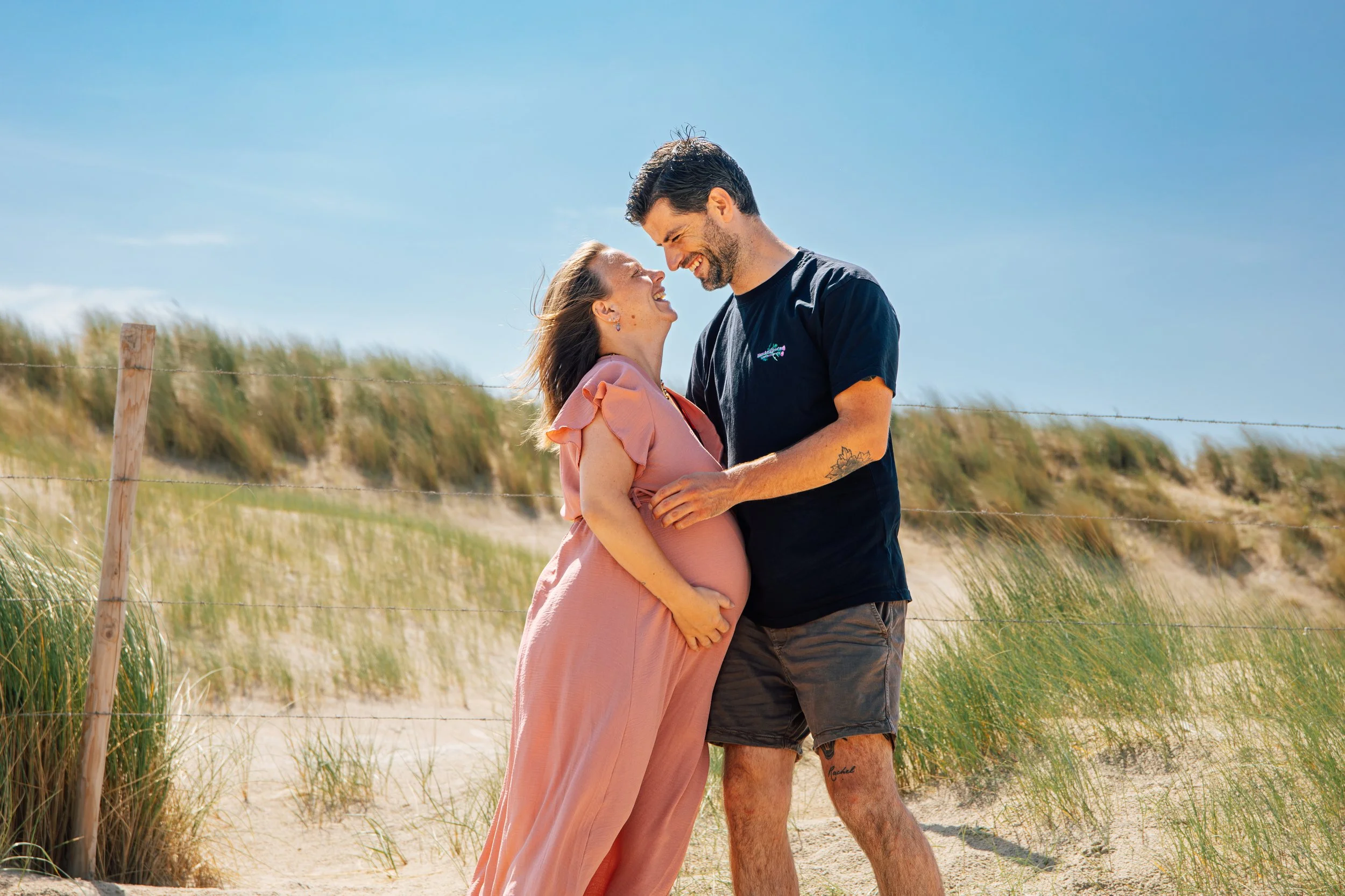 koppelshoot van zwangere vrouw met haar verloofde in de duinen van kijkduin in Nederland