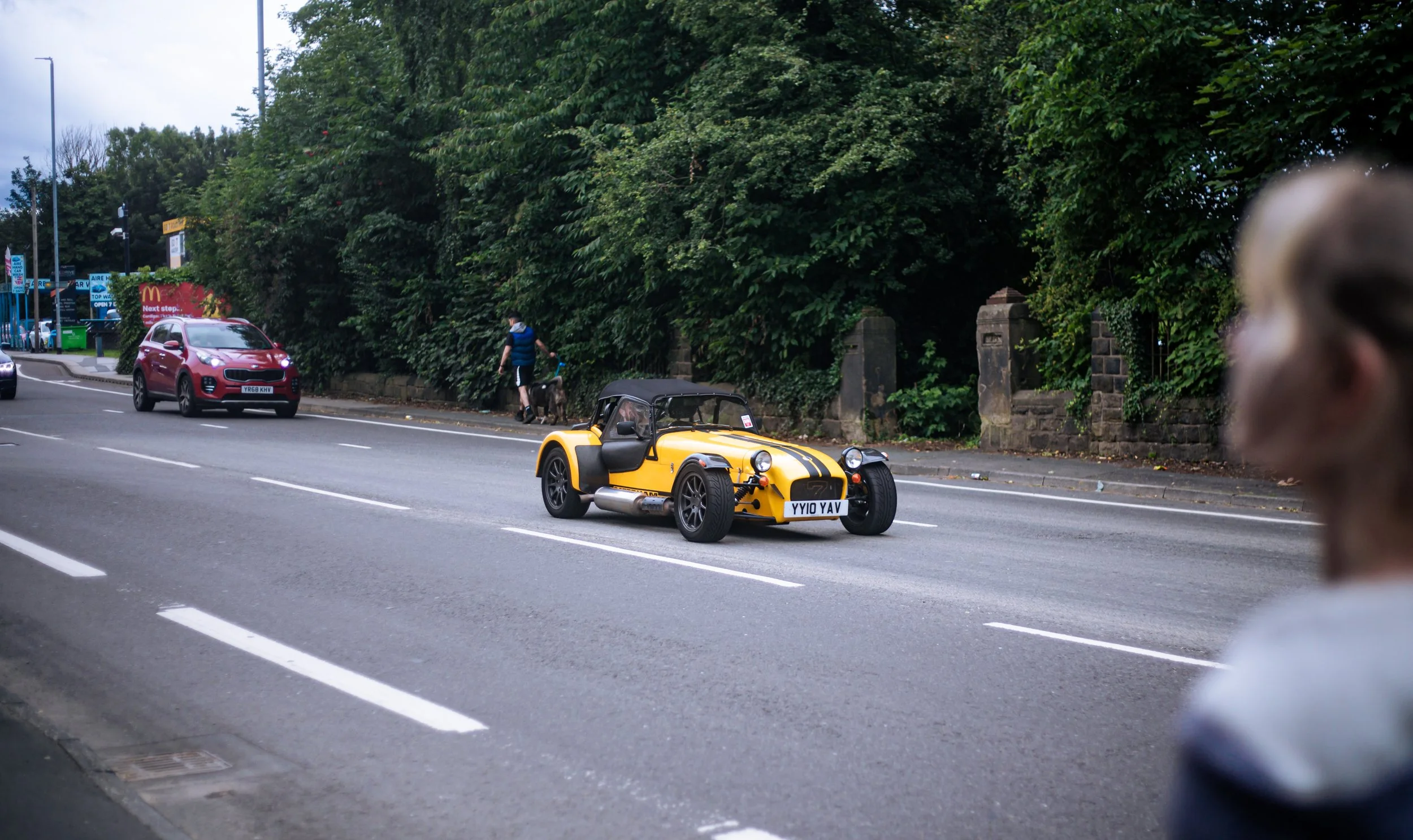Kleine ouderwetse auto schiet langs op de straten van Leeds