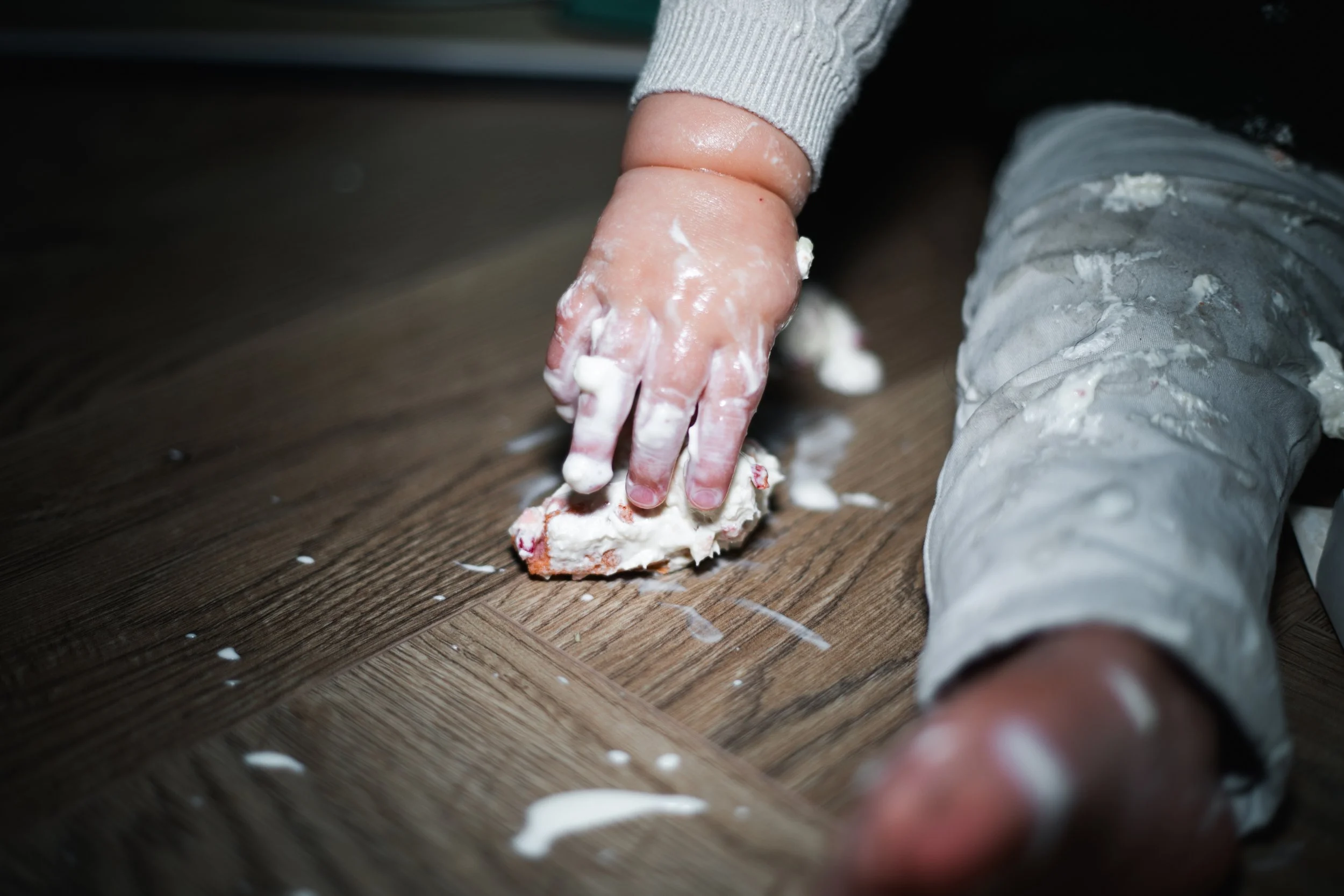 kindje reikt naar een stukje taart tijdens deze cakesmash shoot