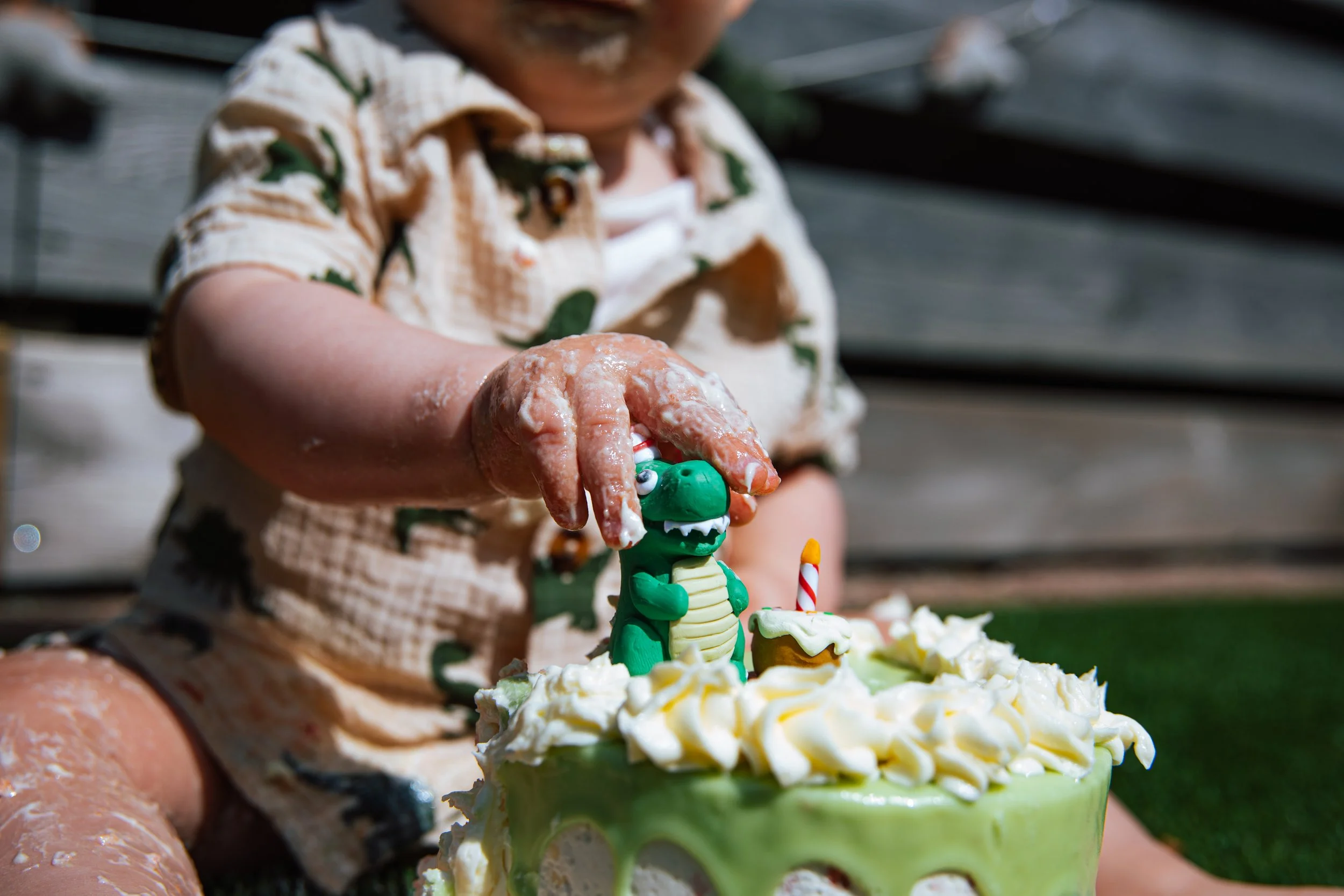 baby pakt speeltje van de taart tijdens een cakesmashshoot met steefclicks