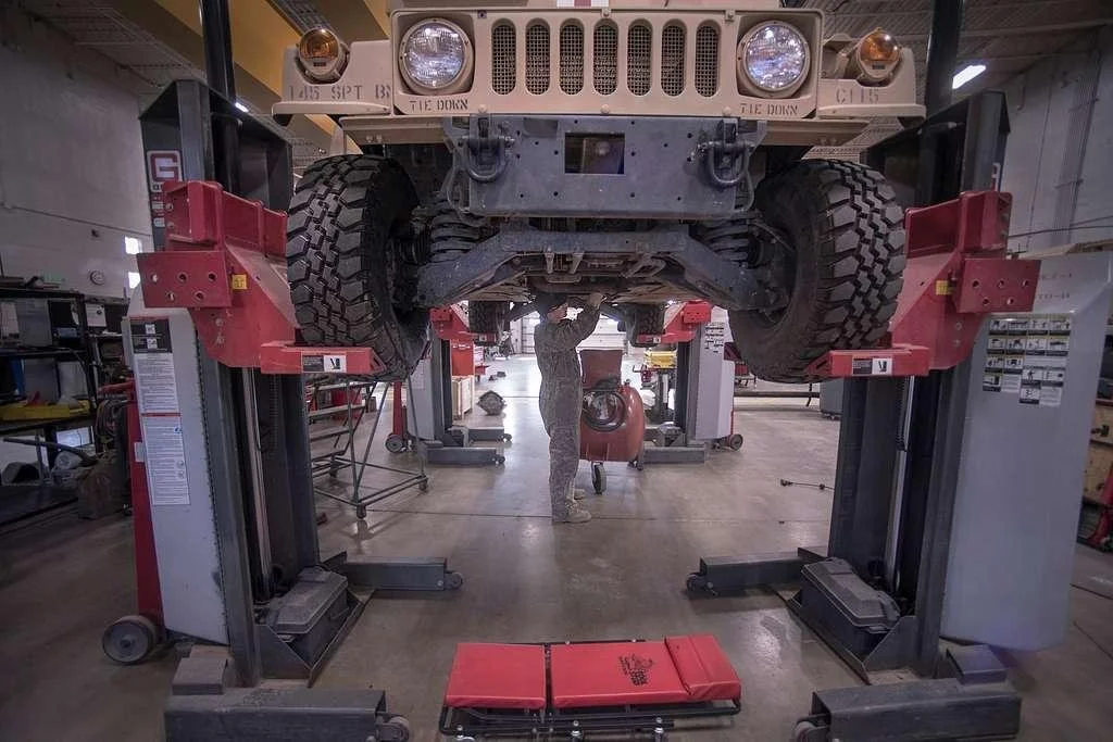 Vehicle raised on a lift inside a government vehicle maintenance facility