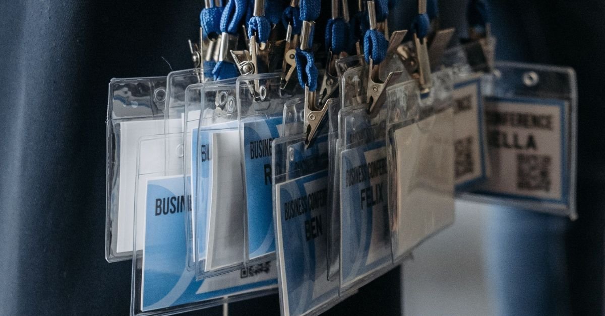 Close-up of blue lanyards with identification badges at an event.