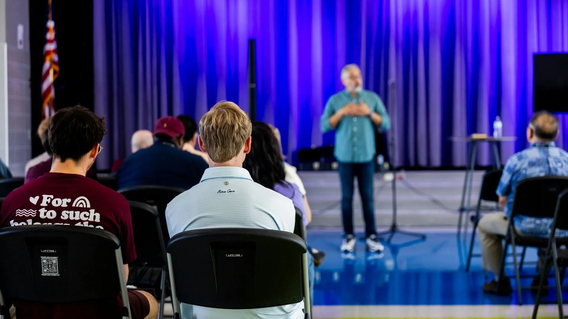 Audience seated listening to speaker on stage presentation