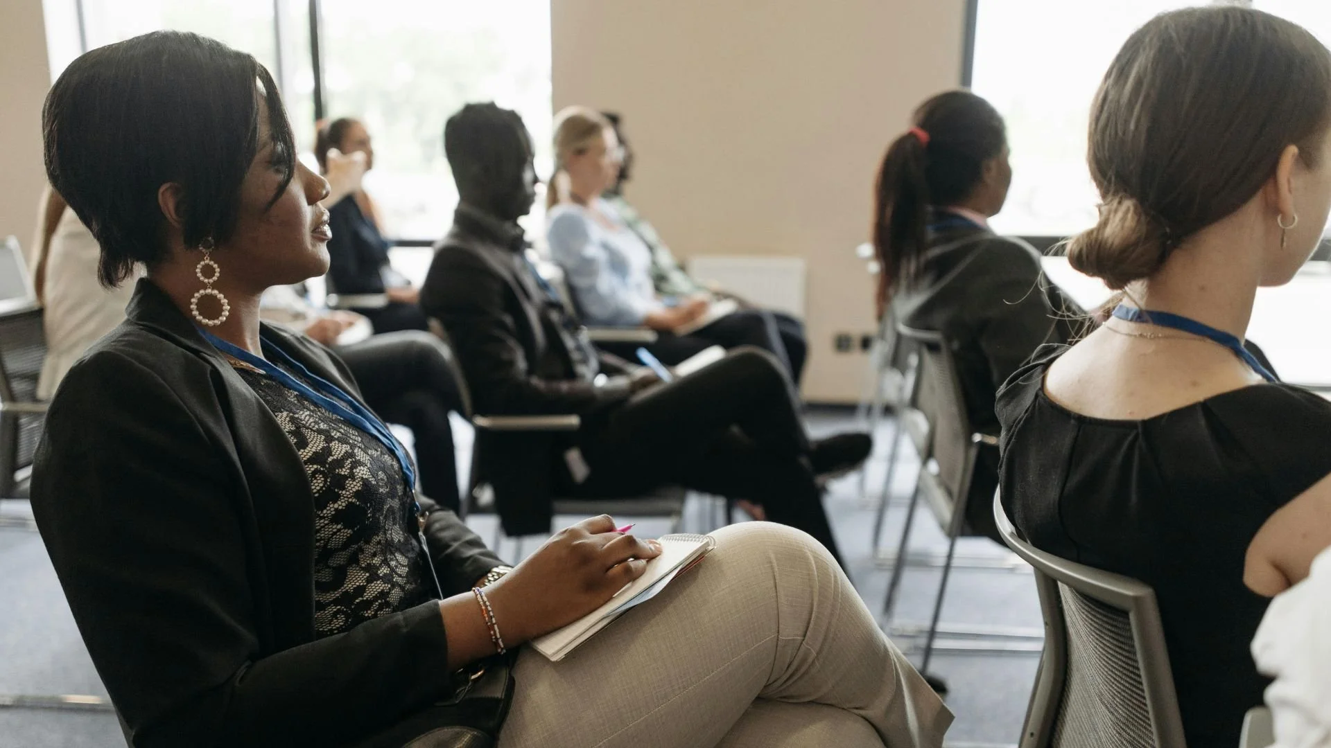 Professionals attending seminar taking notes during business presentation