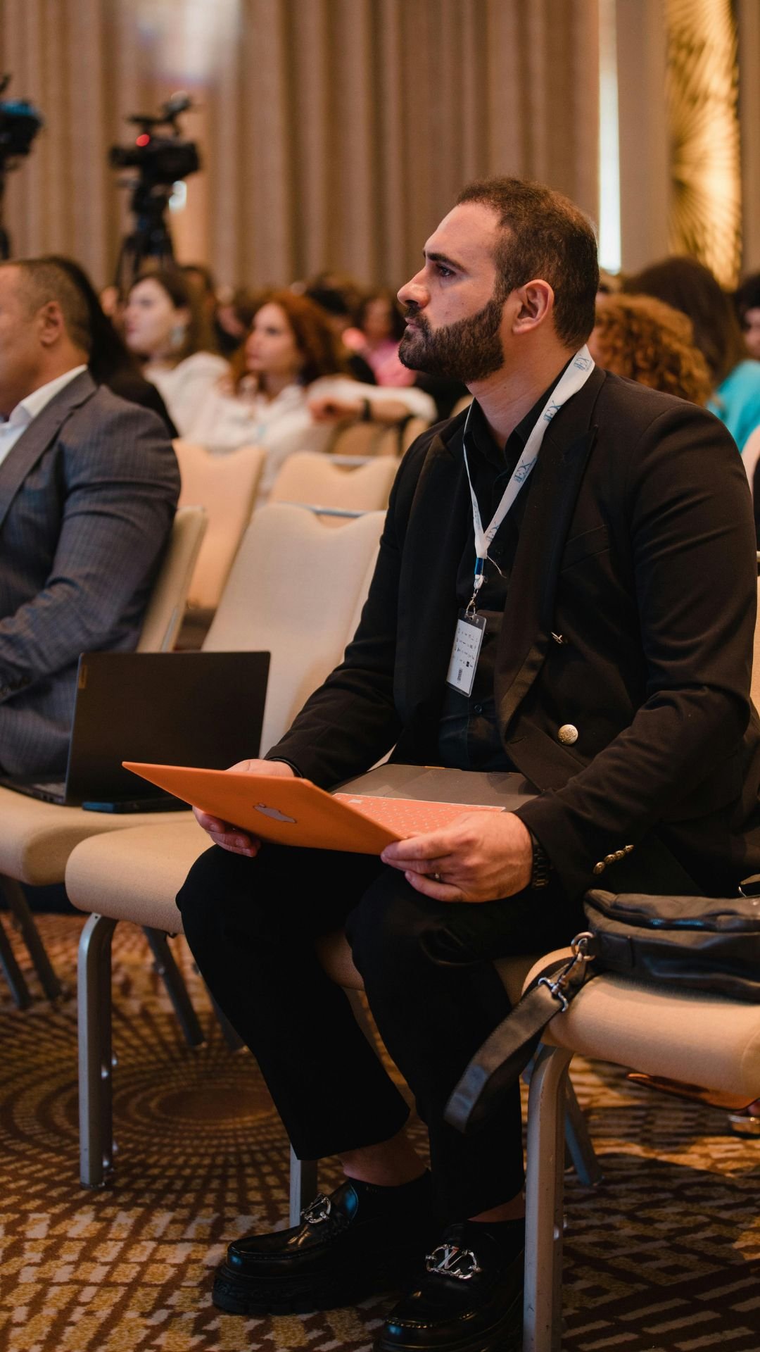 Business professional attending conference using laptop and tablet