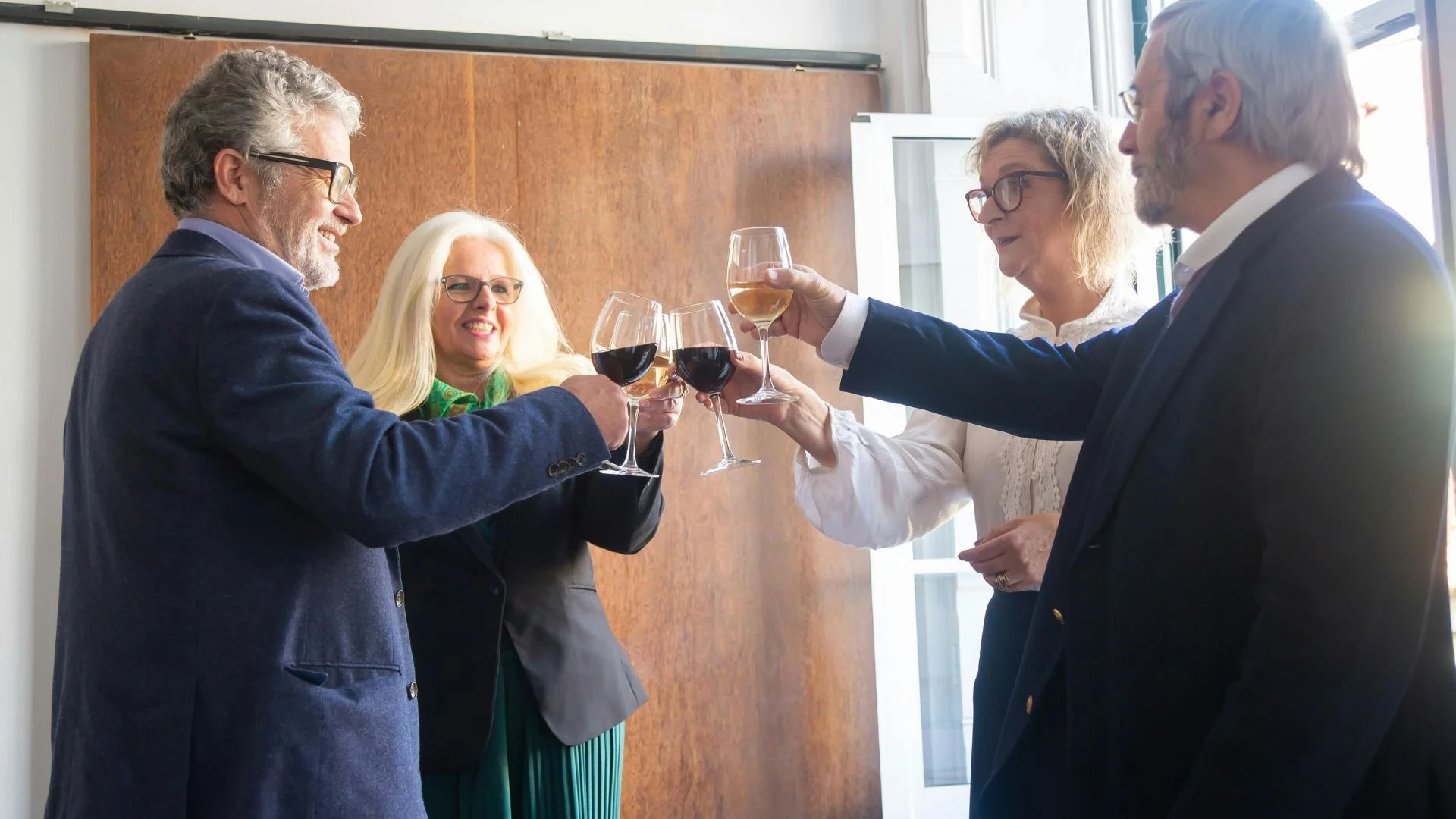 Colleagues celebrating together with wine glasses at corporate event