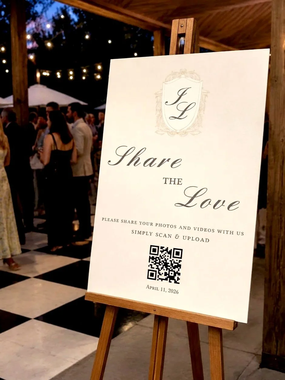 Large QR code poster on an easel in a wedding cocktail area for photo sharing