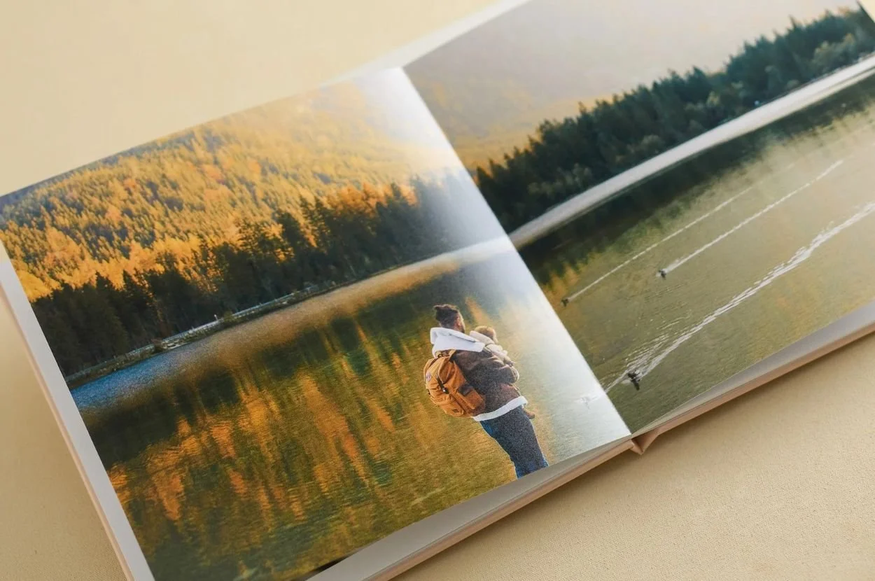 Open photo book showing scenic lakeside forest memories
