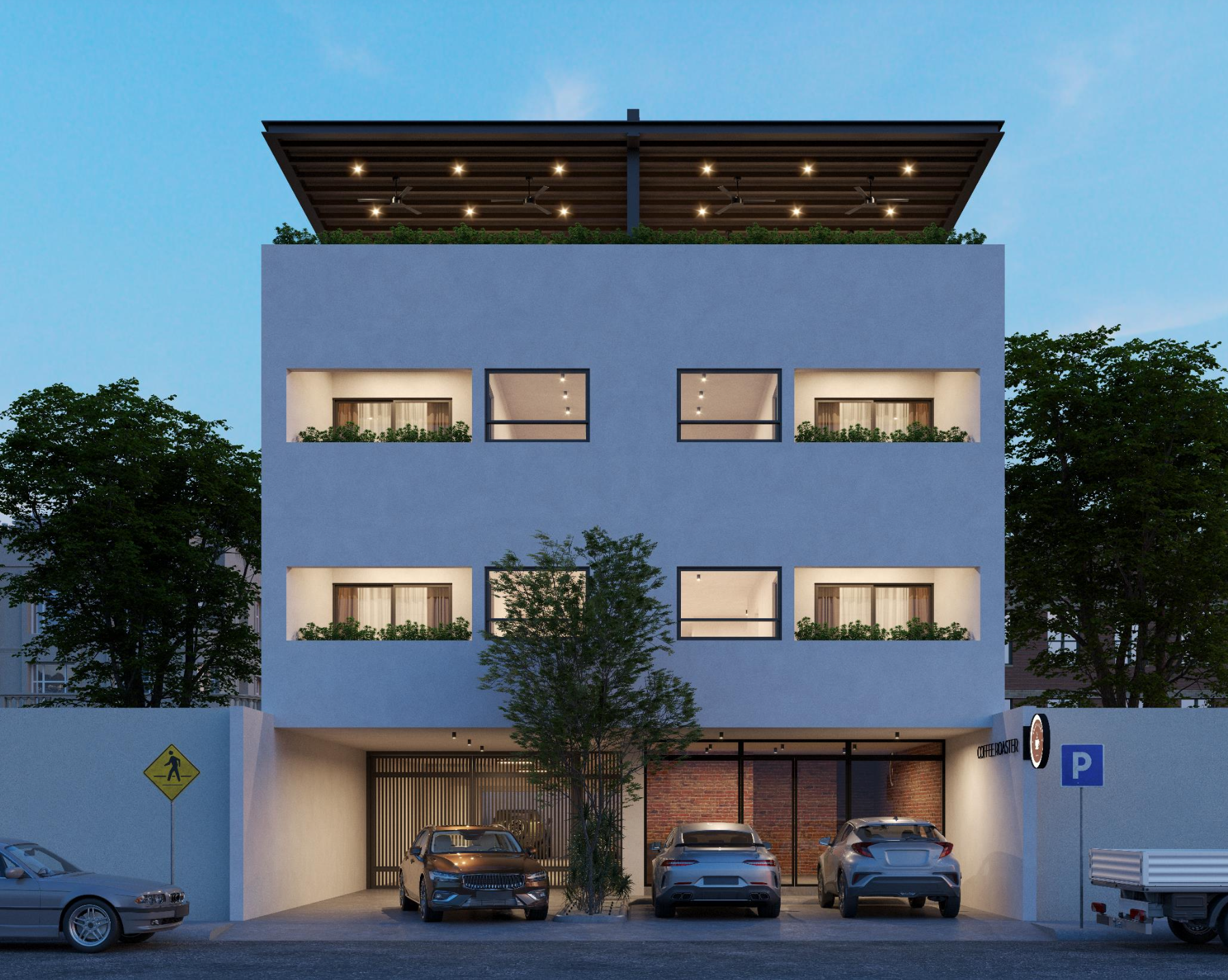 Edificio moderno de cuatro pisos con estacionamiento en la planta baja, árboles en la calle y señal de cruce peatonal, durante el atardecer.