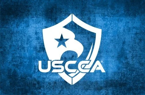 USCCA logo with a shield and star on a blue textured background.