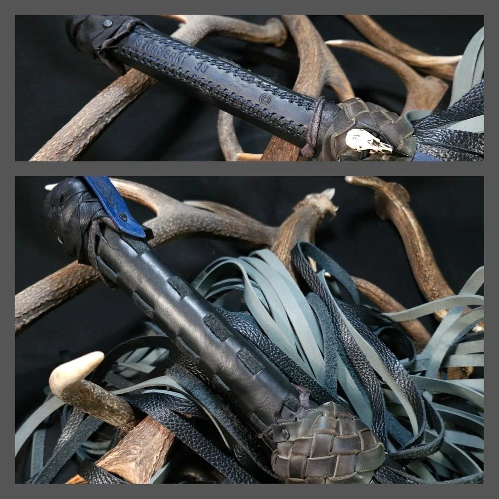 Close-up of climbing gear accessories, including a black carabiner and a camouflaged climbing shoe, placed on branches.