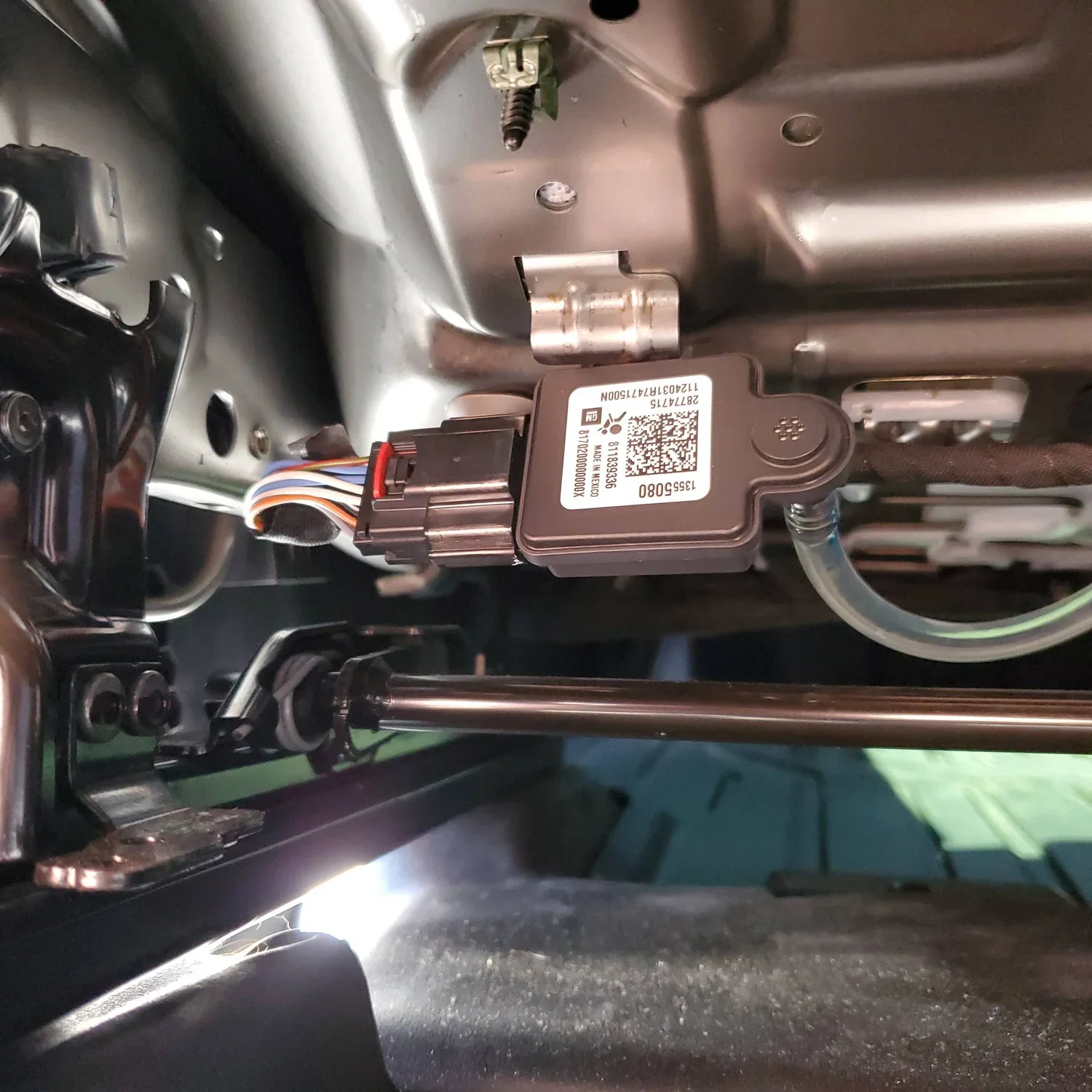 View of a GM OCS sensor under the driver's seat. The sensor measures the pressure in a fluid-filled bladder mounted under the seat cushion, and informs systems accordingly.