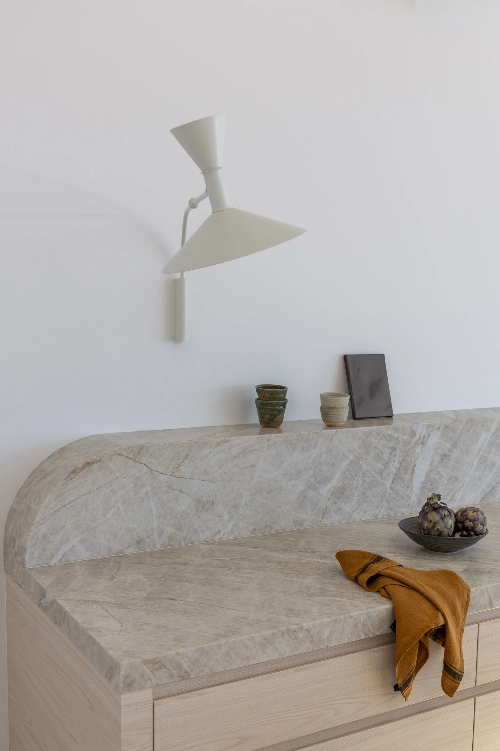 Modern white and light timber kitchen with feature stone bench tops and feature lighting