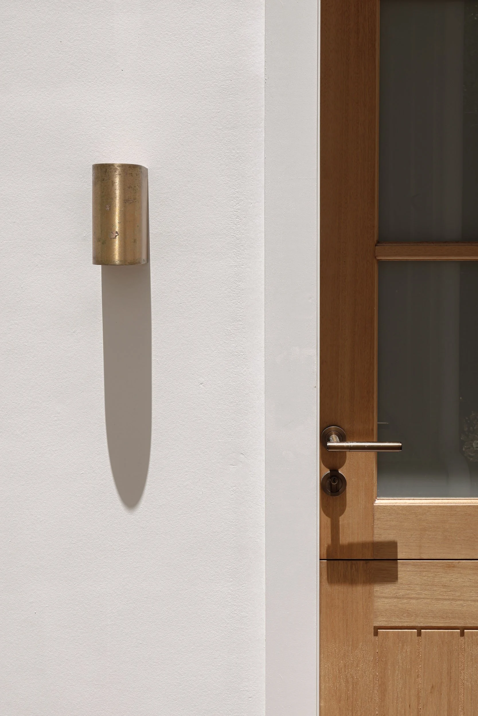 Modern white exterior with natural timber stable front door, antique brass light, antique brass handle, james hardie white cladding