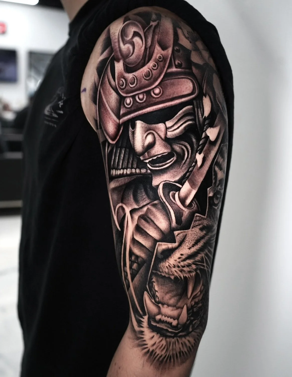 Black and gray tattoo sleeve featuring a samurai warrior with a fierce expression and a snarling wolf.
