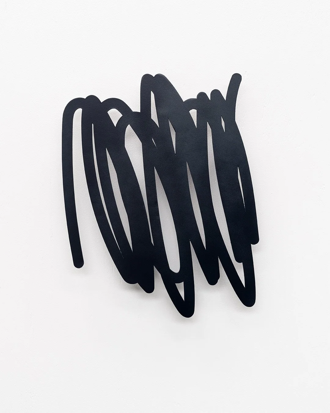 Christchurch, New Zealand artist, Nathan Ingram's black abstract wall sculpture with overlapping curved lines on white wall