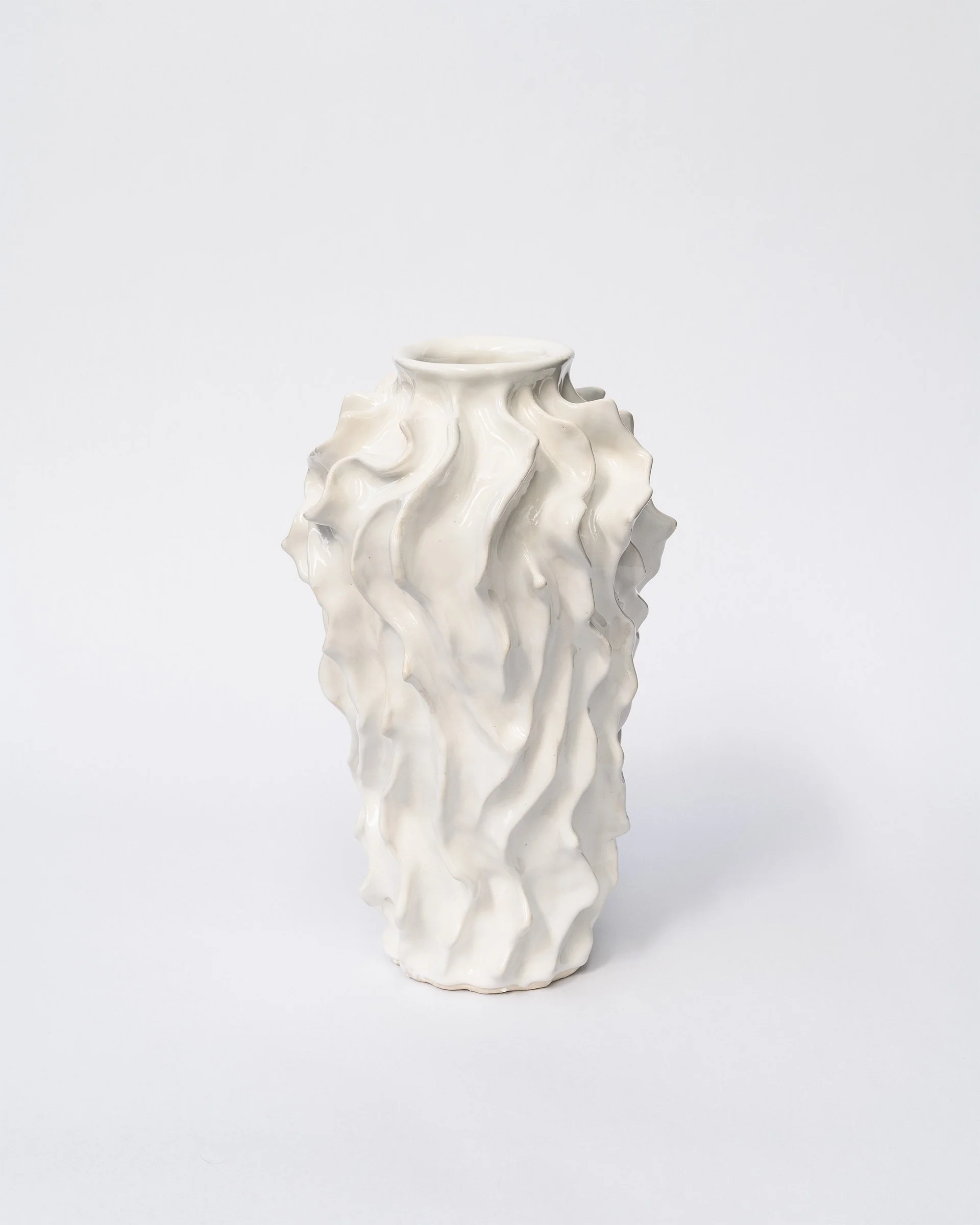 White ceramic vase with a textured, wavy, and irregular surface design on a plain white background.