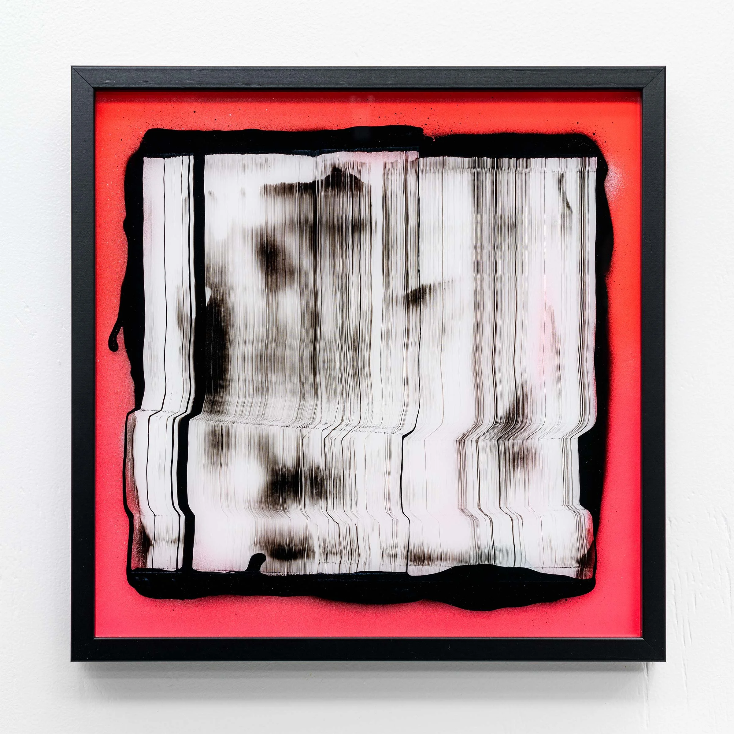 Abstract art piece with a distorted portrait on a pink background, framed in black.