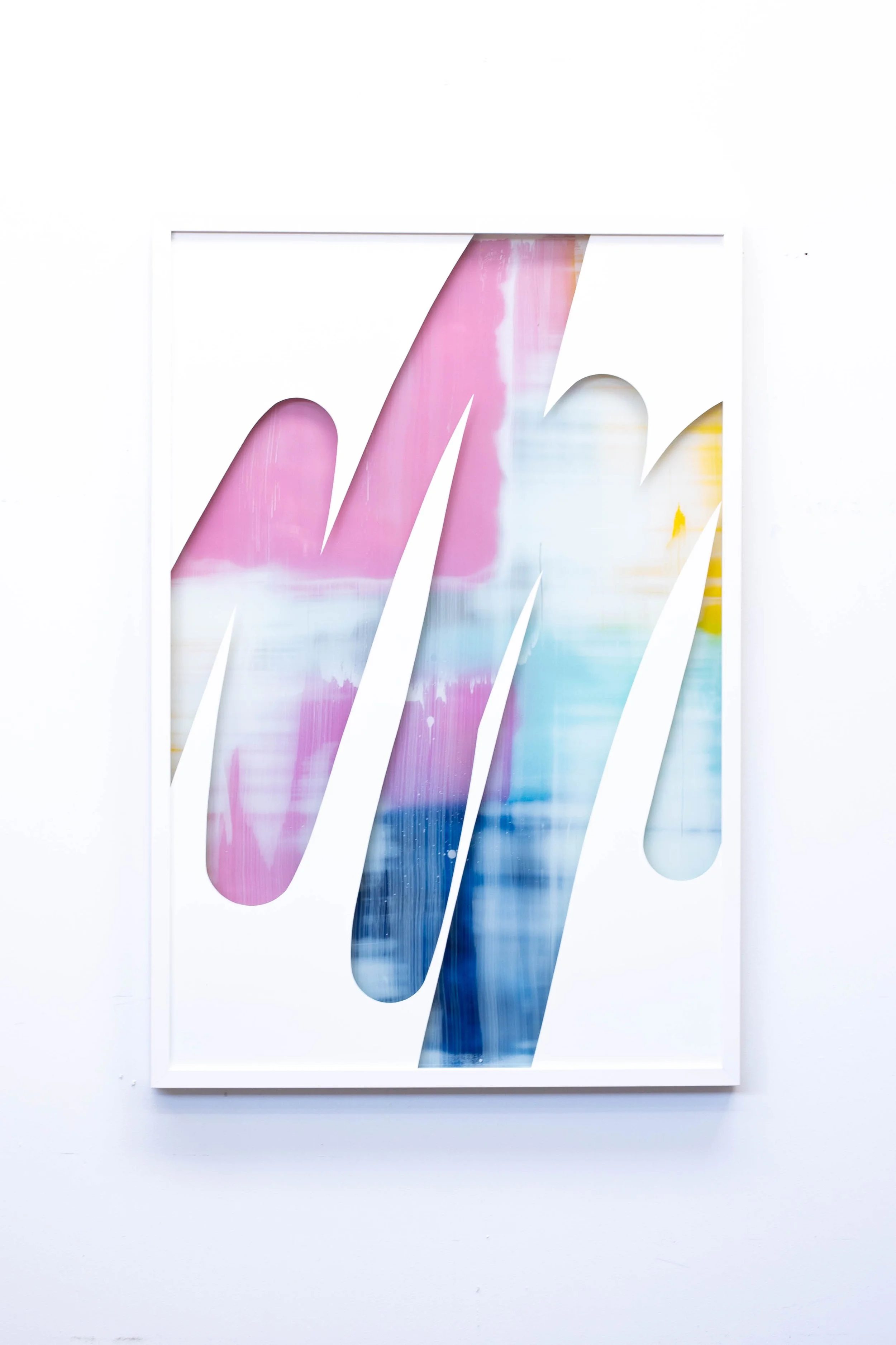 Christchurch, New Zealand artist, Nathan Ingram's abstract artwork with colorful brush strokes seen through cutout sections in a white frame.