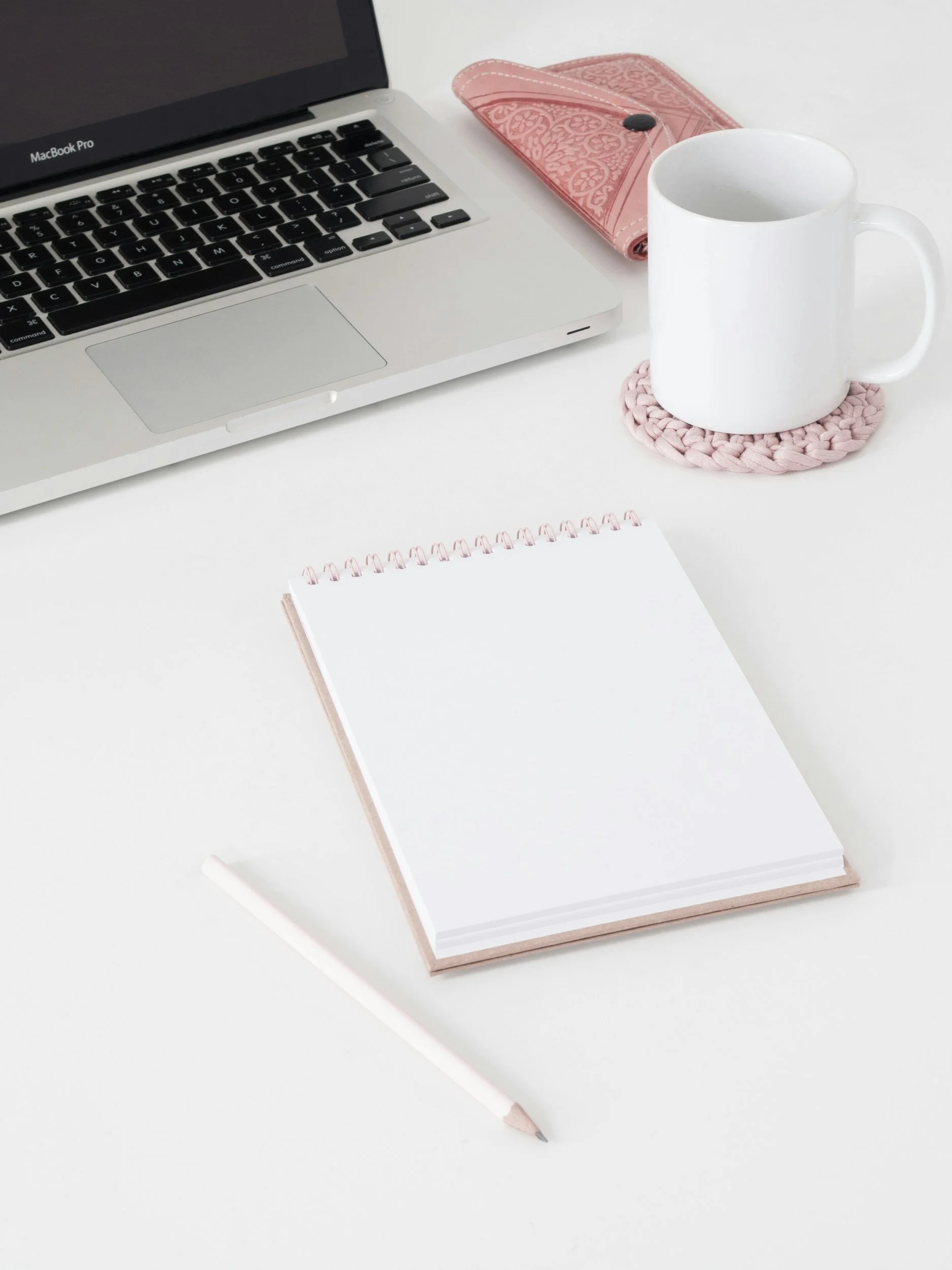 A white desk with a silver MacBook Pro laptop on a desk for online business management support for busy women entrepreneurs
