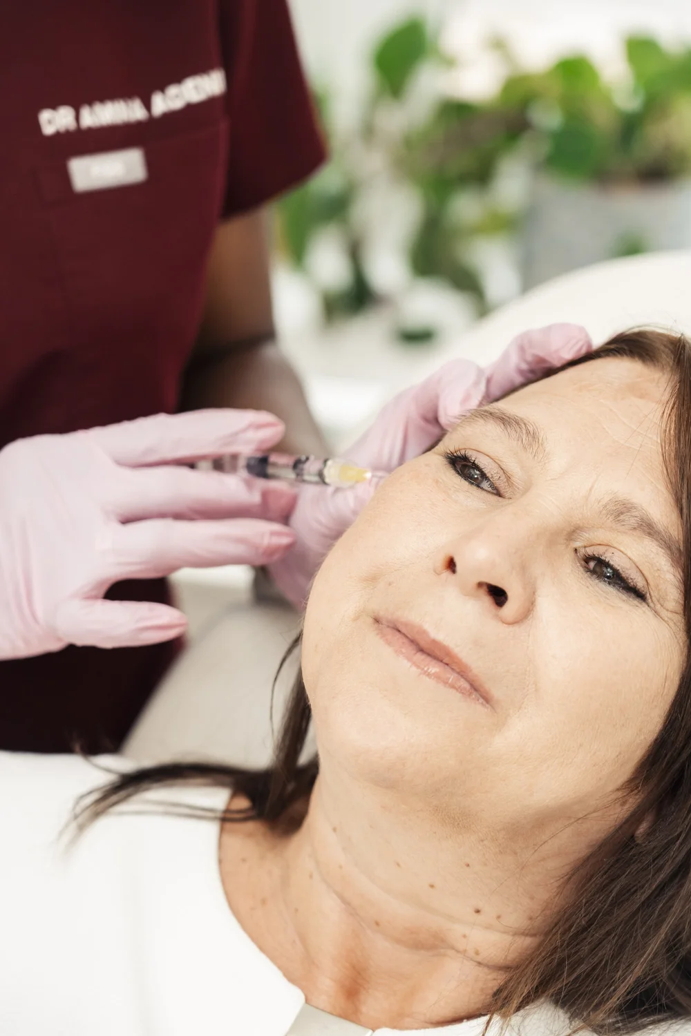 Dr Amina Adeniran carrying out a facial treatment on a patient