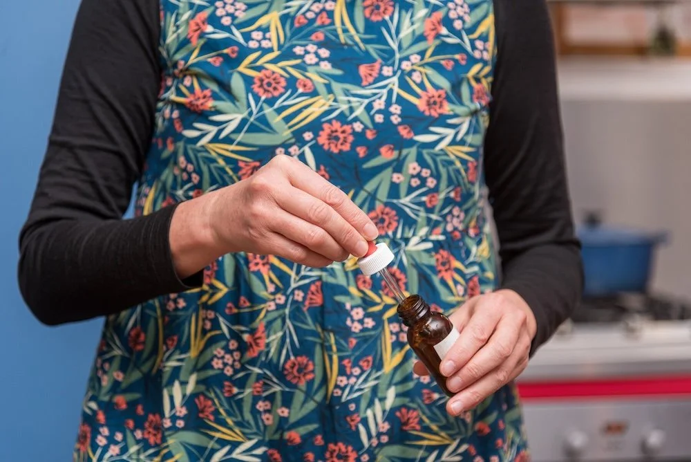 Pouring herbal drops into glass vial – crafting individualised herbal remedies for brain and gut support
