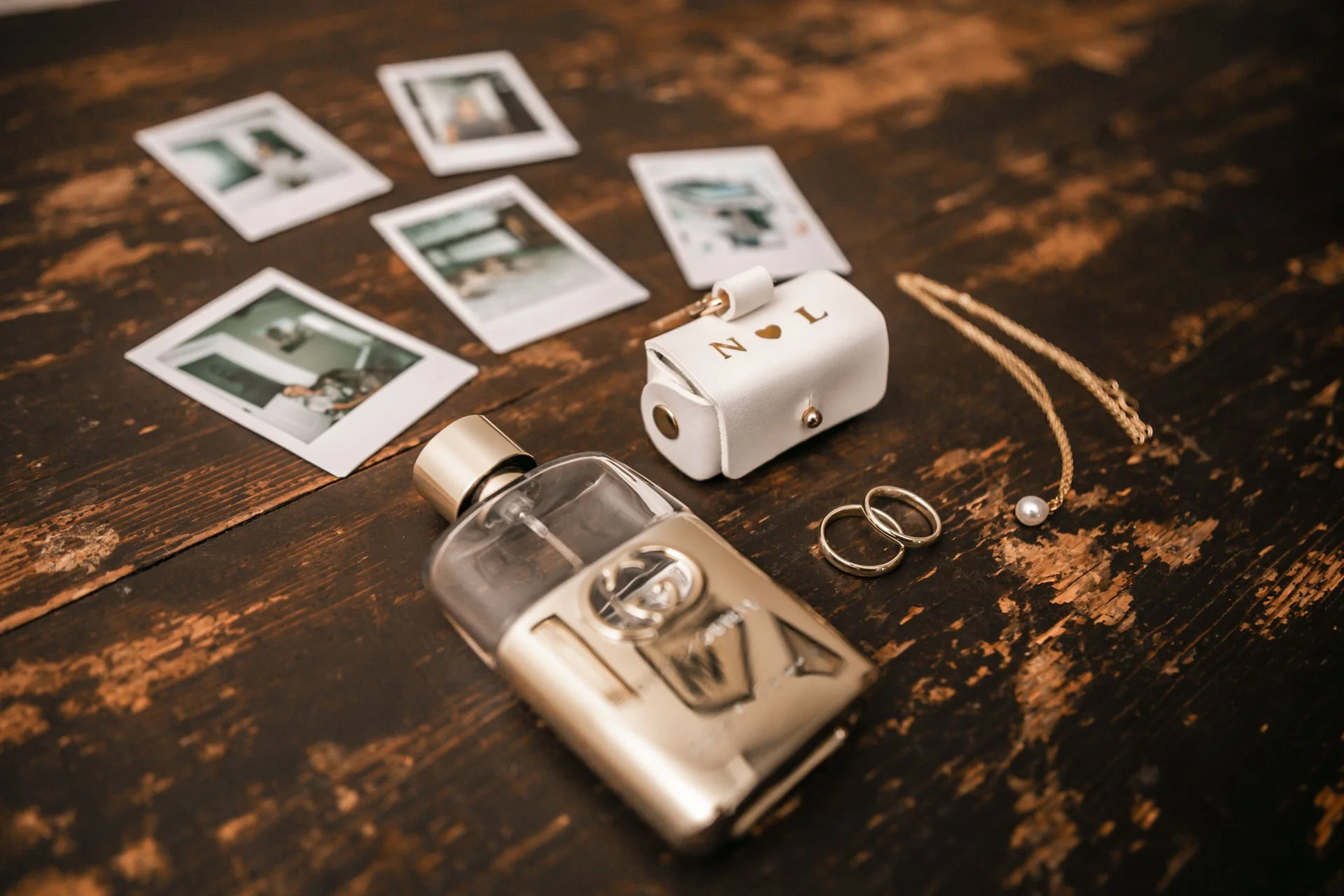 Eheringe, Parfum, Fliege und Polaroidfotos beim Getting Ready des Bräutigams