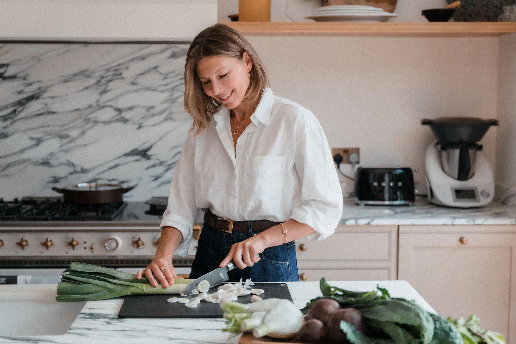 Midlife woman with vegetables in her kitchen – perimenopause nutritionist helping women with strange perimenopause symptoms