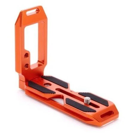 An orange camera tripod plate with black grip pads and a screw mount.