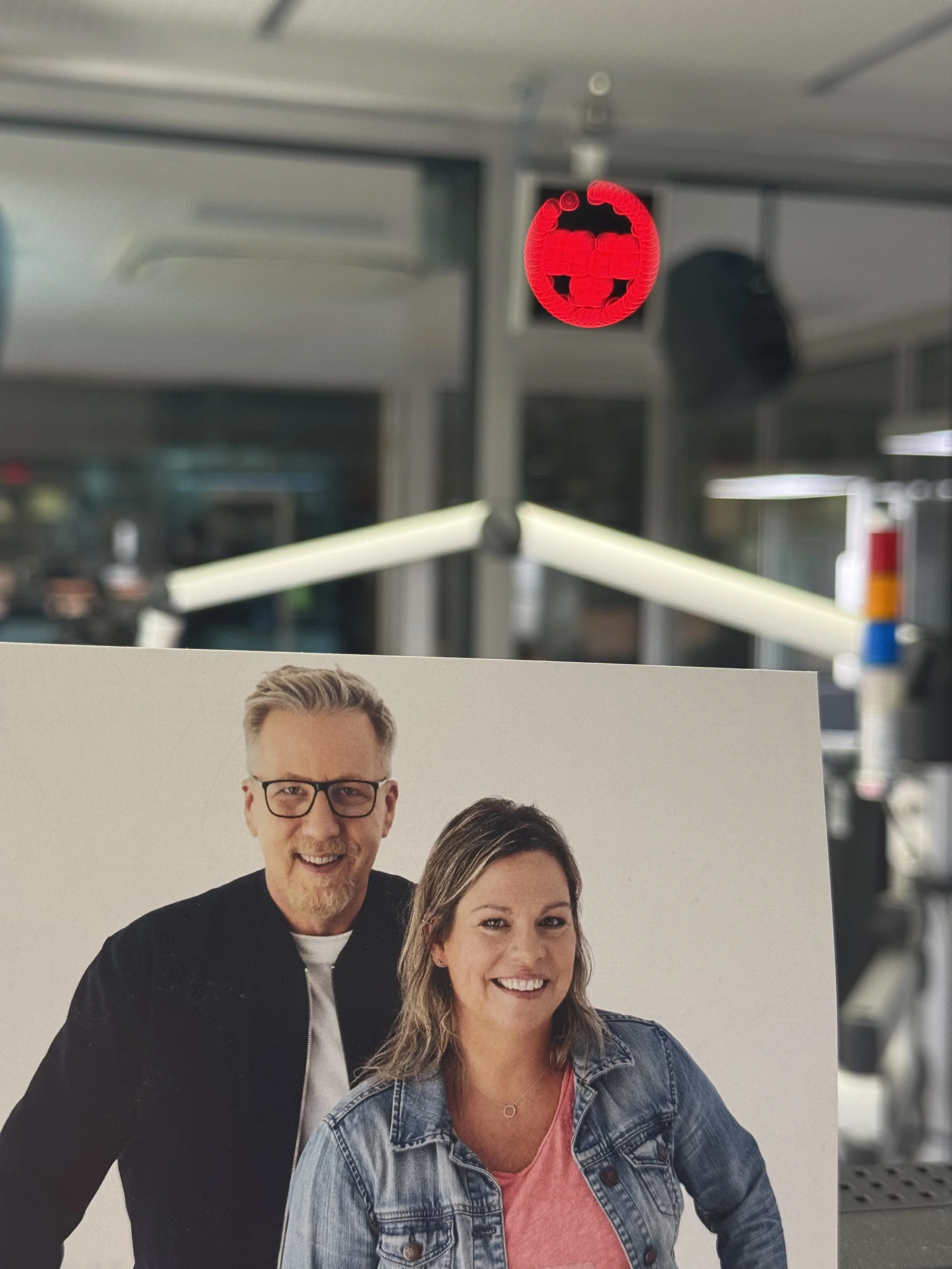 Ein Fotoposter mit Jan Malte Andresen und einer lachenden Conny Raupold mit braunen Haaren im WDR2 Studio