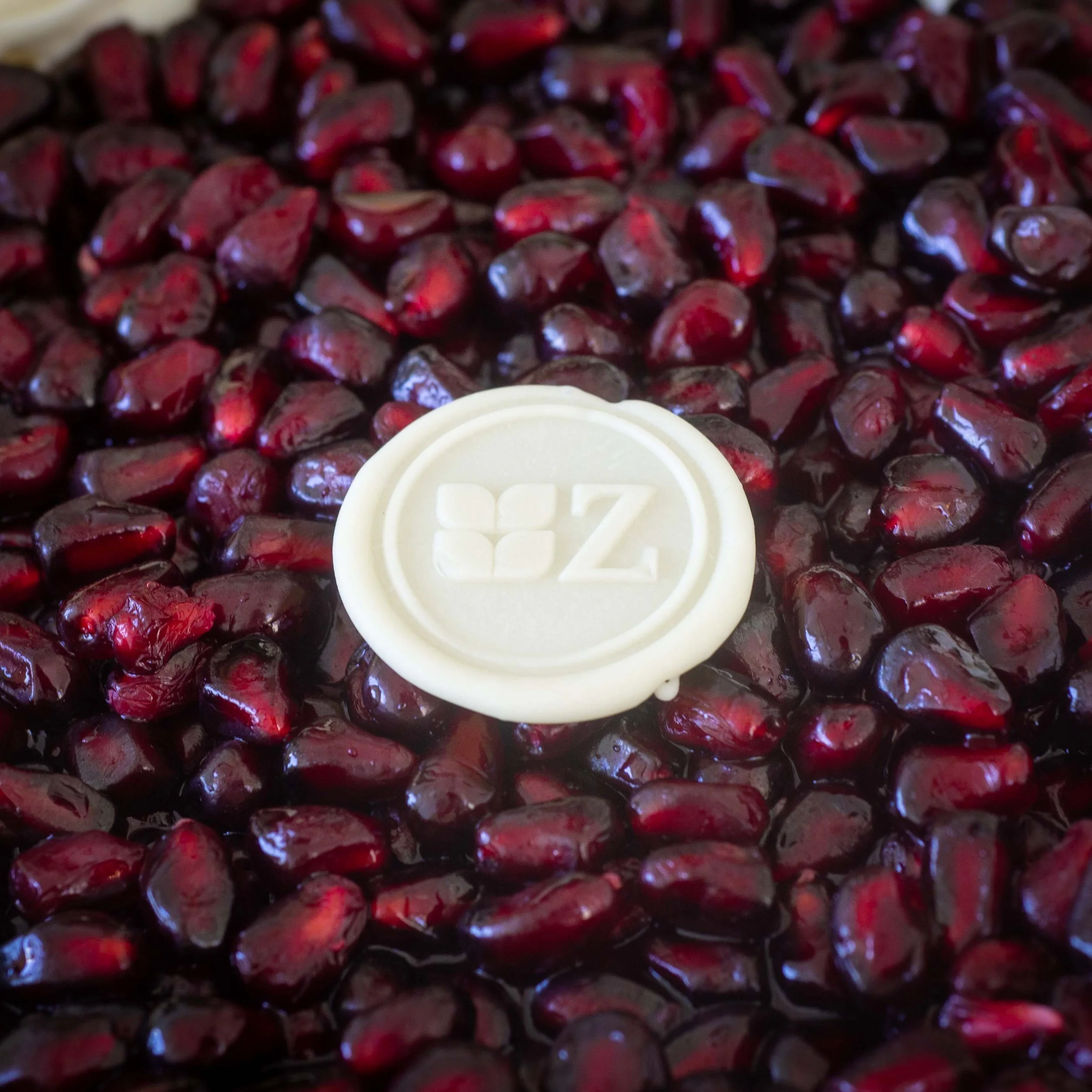 a close up of the top of a pomegranate mousse cake with pomegranate seeds