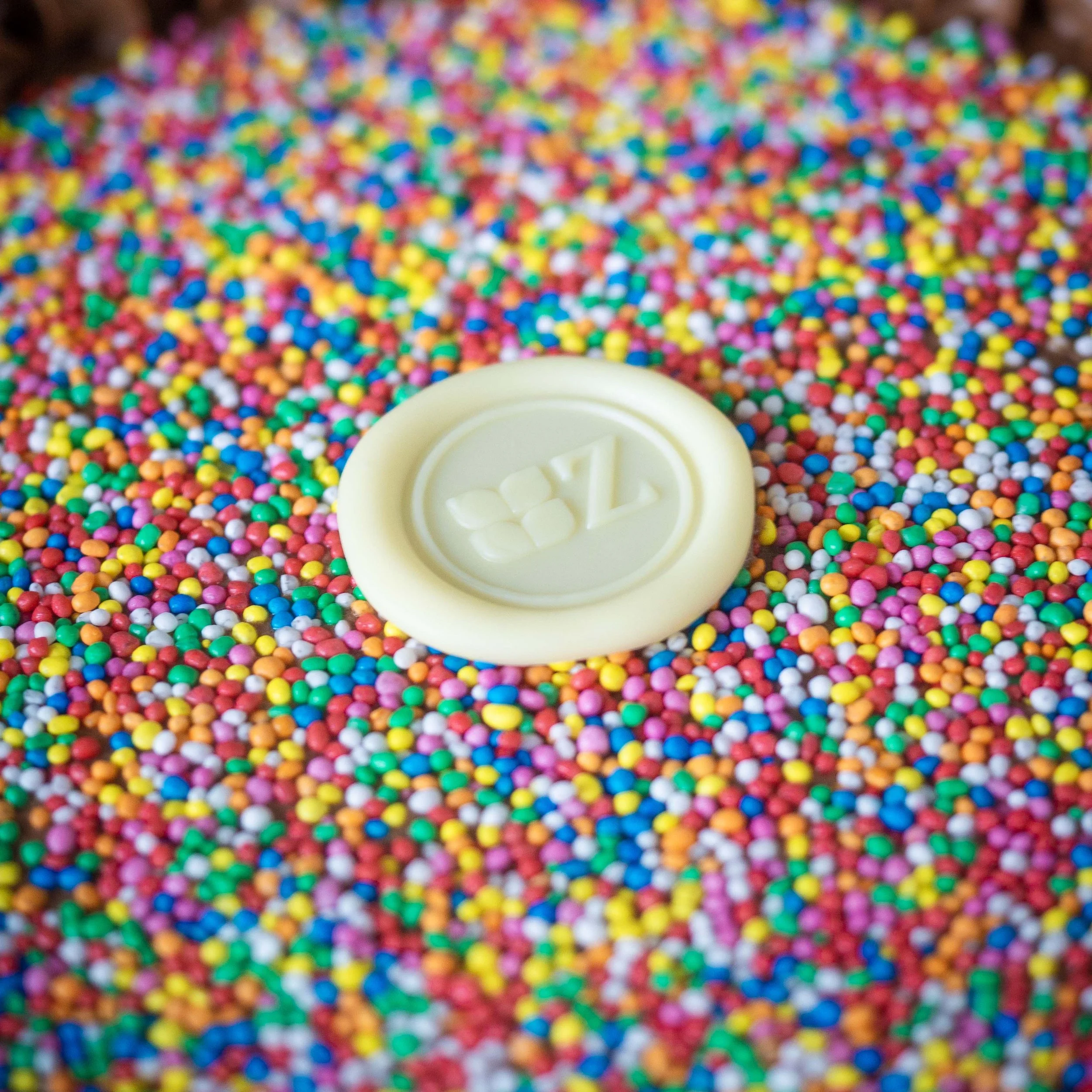 a close up of the sprinkles on top of a chocolate birthday cake