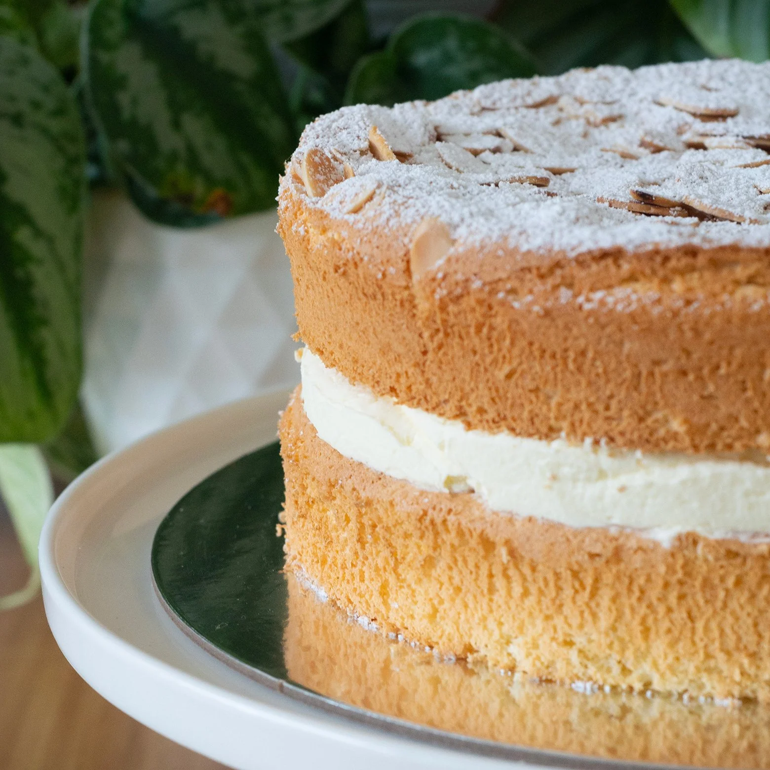 a sponge cake filled with lemon curd and cream and topped with toasted almonds