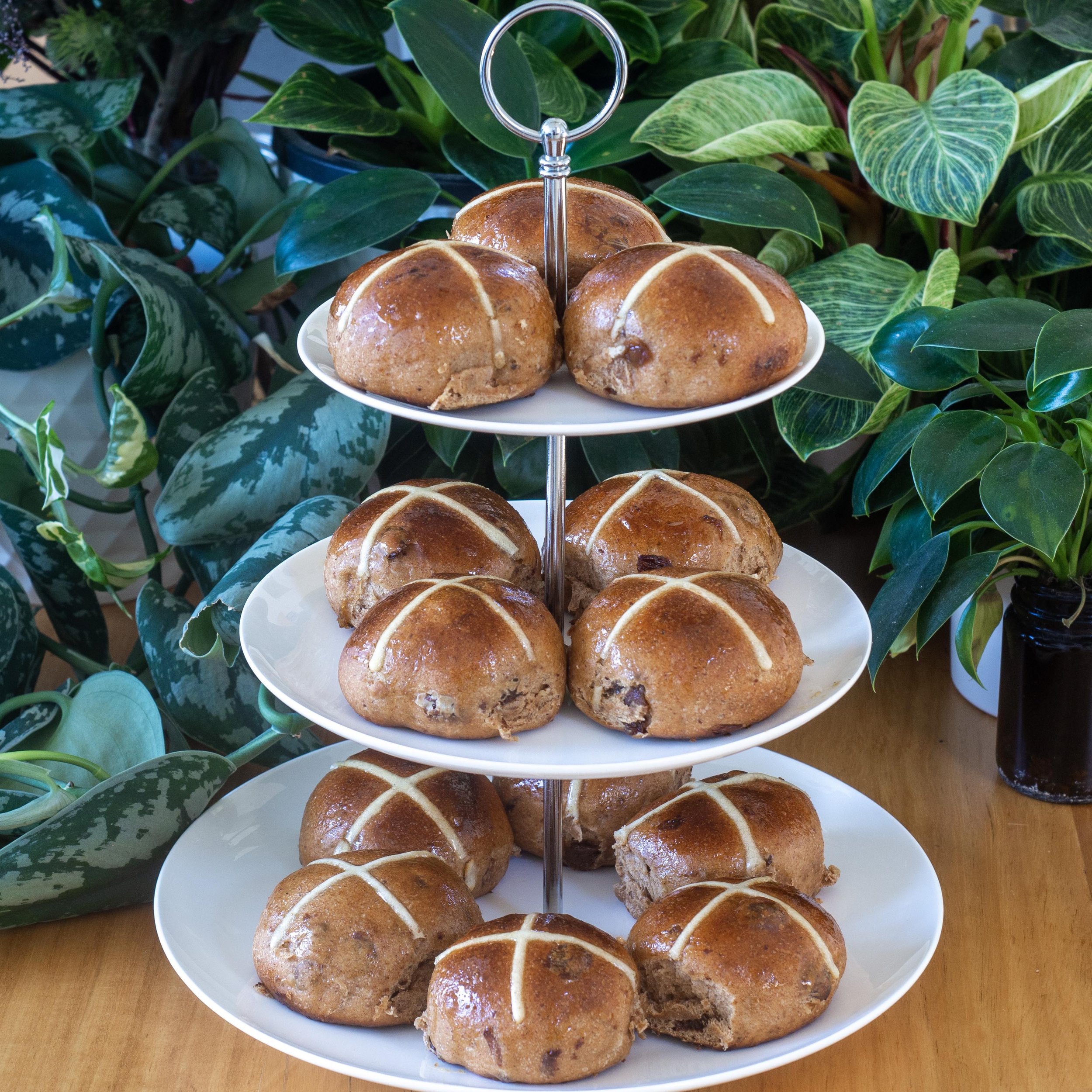 a cake stand filled with hot cross buns