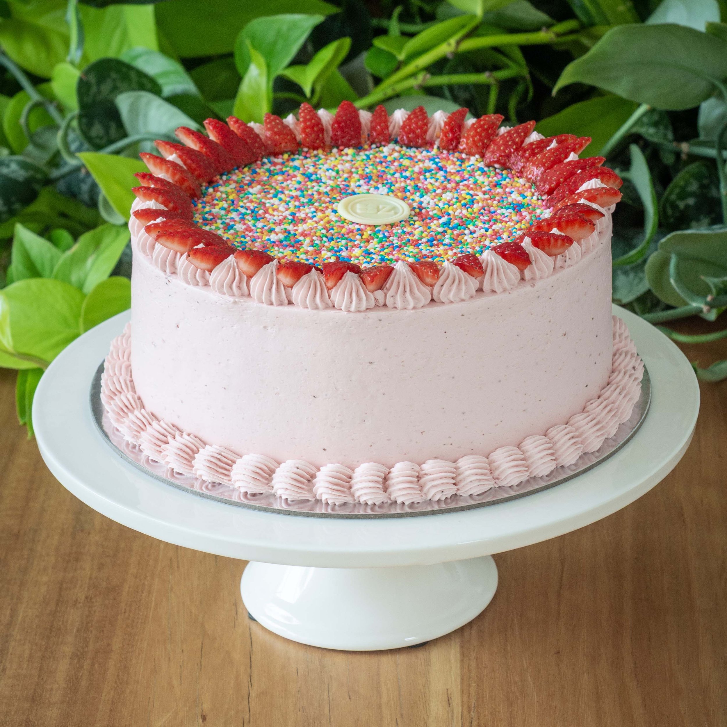 a pink strawberry cake with sprinkles perfect for kids birthday parties