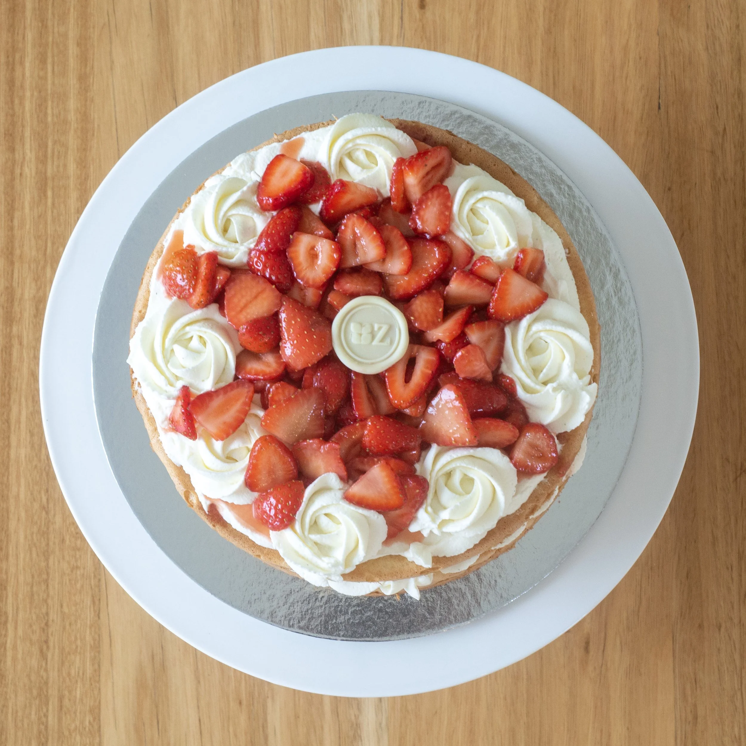 a view from above of a fancy British Victoria Sponge with macerated strawberries