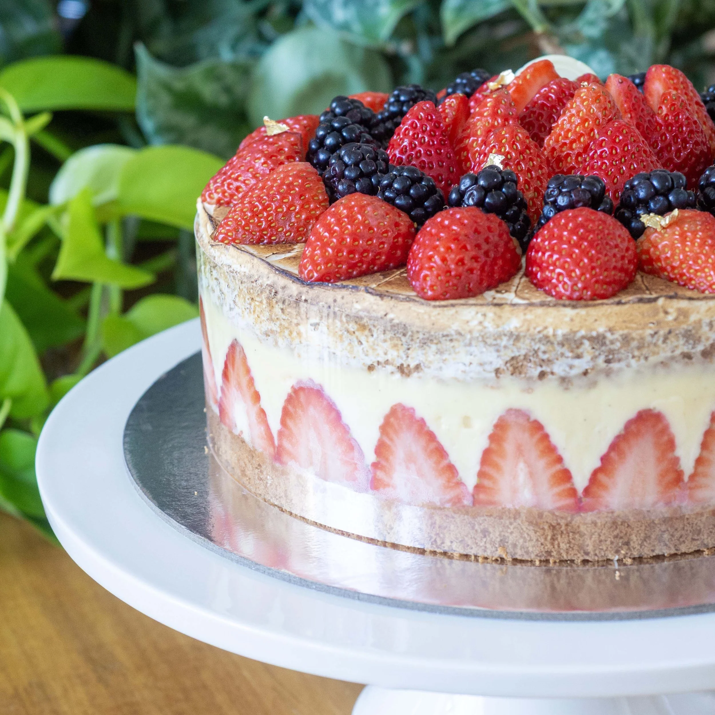 a side view of a french strawberry cake or fraisier with visible strawberry decoration