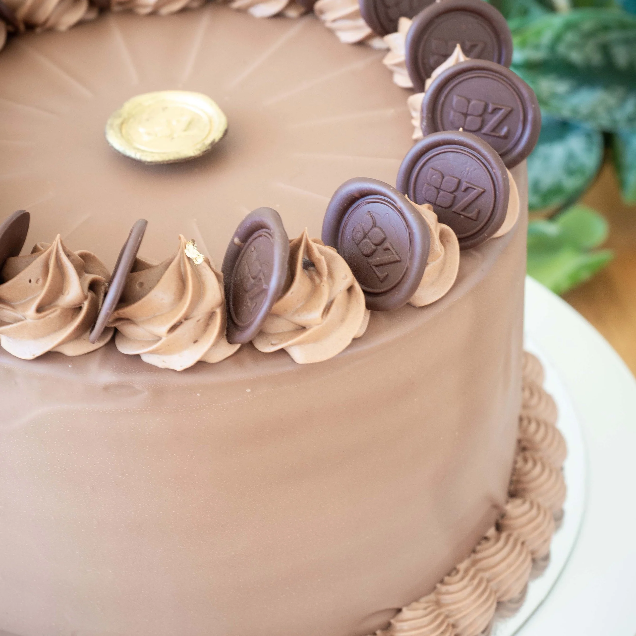 a close up of the decoration on a chocolate covered multi layered German Prinzregententorte cake