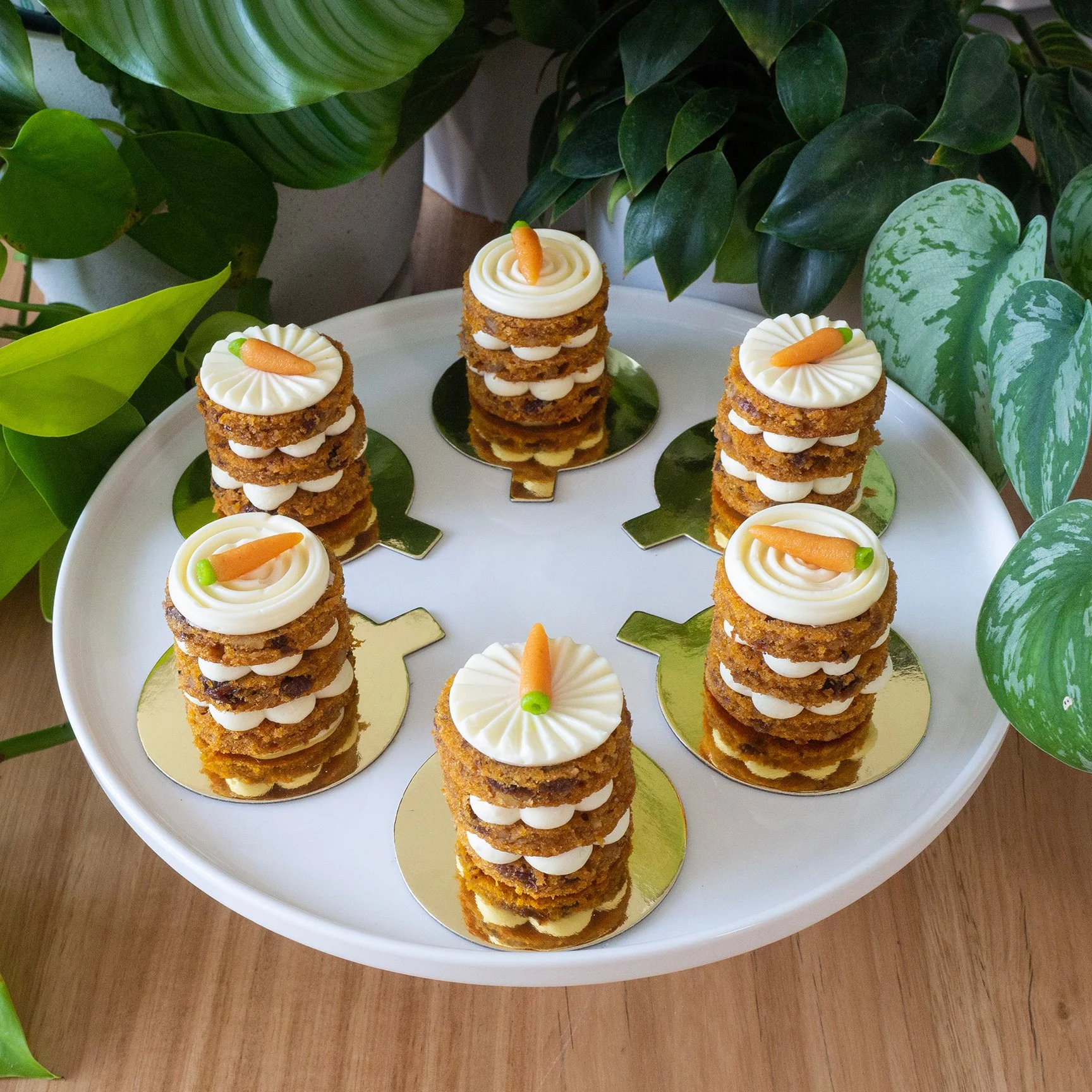 six carrot cake petits gateaux on a white cake stand