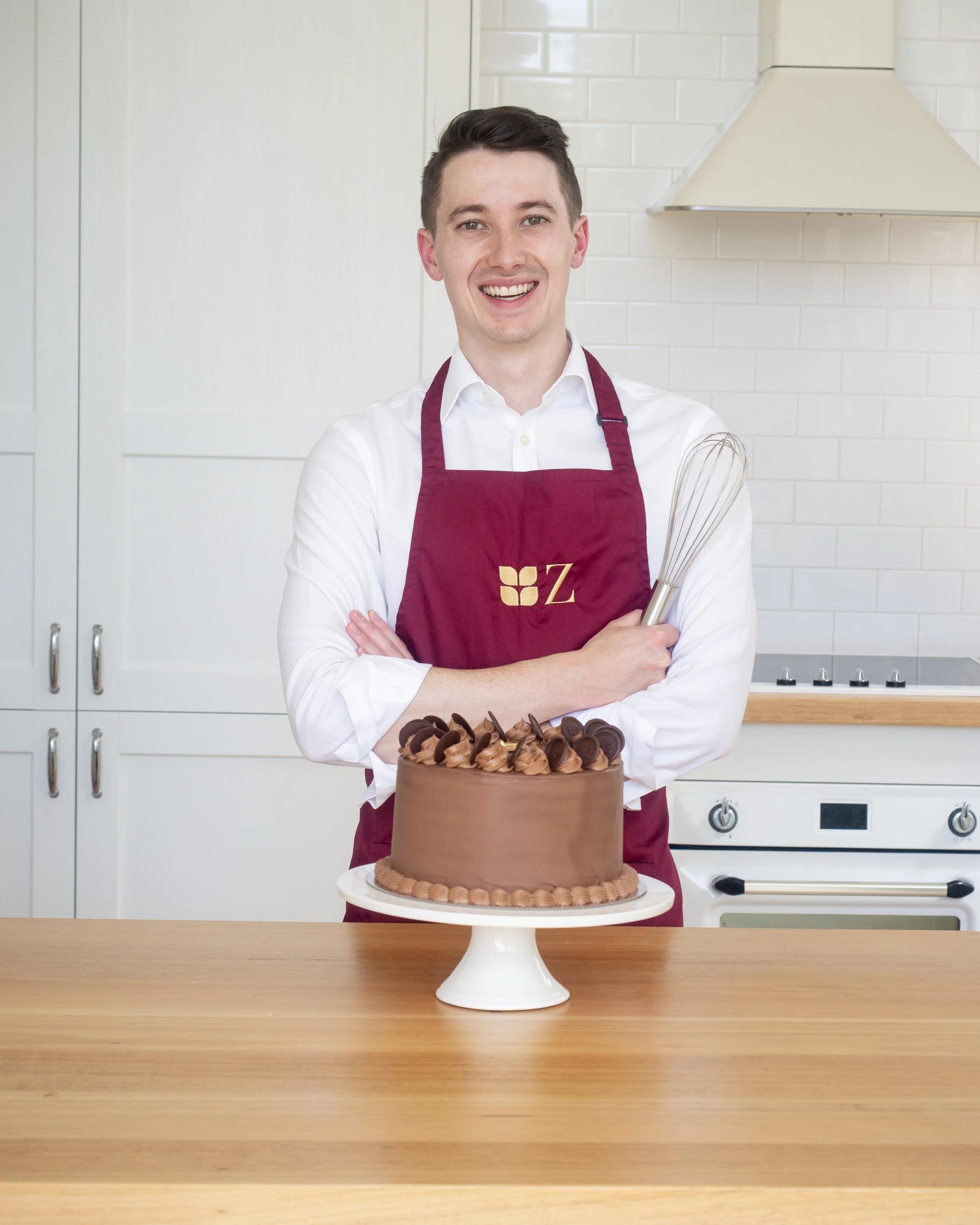 Zuckerhaus founder Nick posing with a Prinzregententorte in the Zuckerhaus kitchen