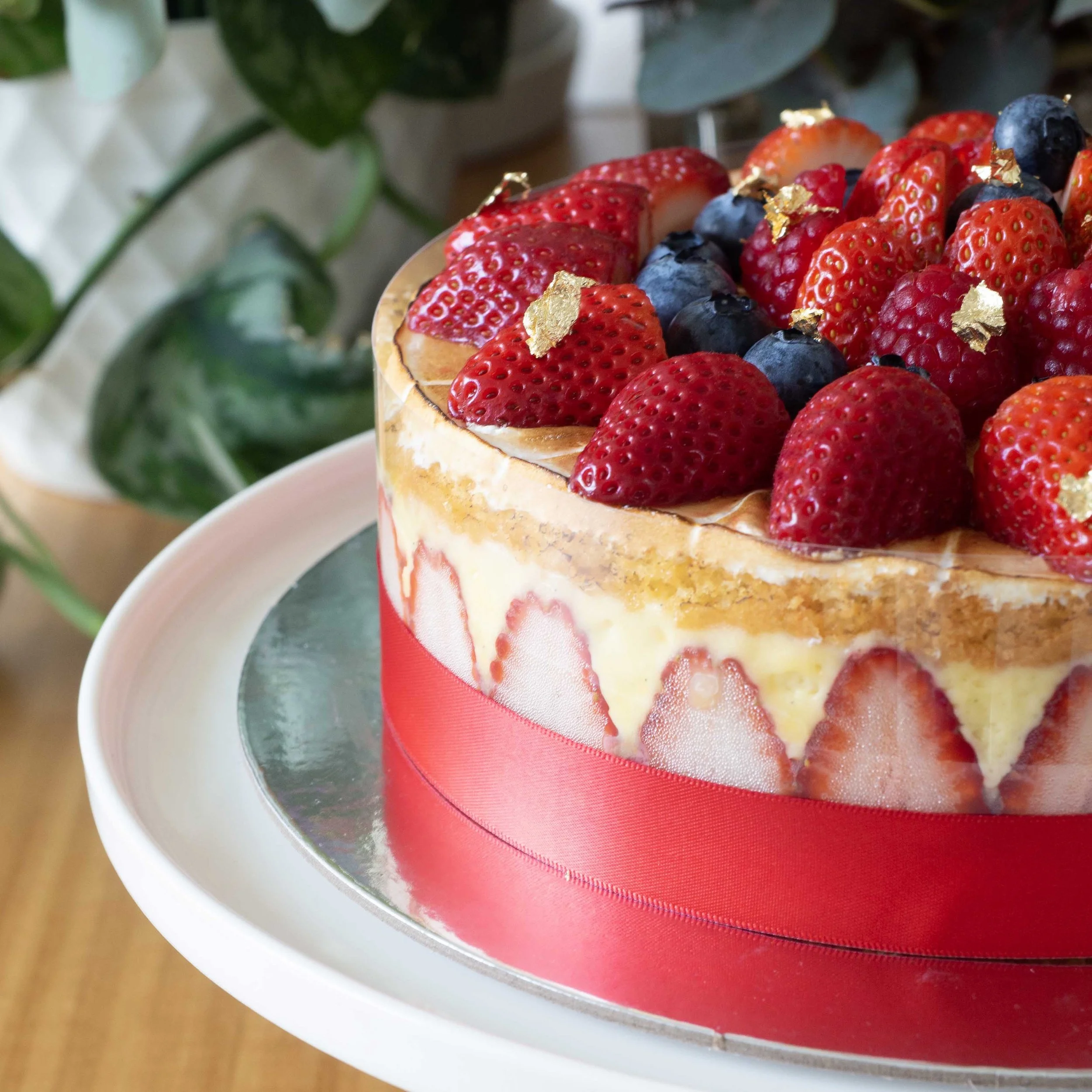a side view of a french strawberry cake or fraisier with visible strawberry decoration