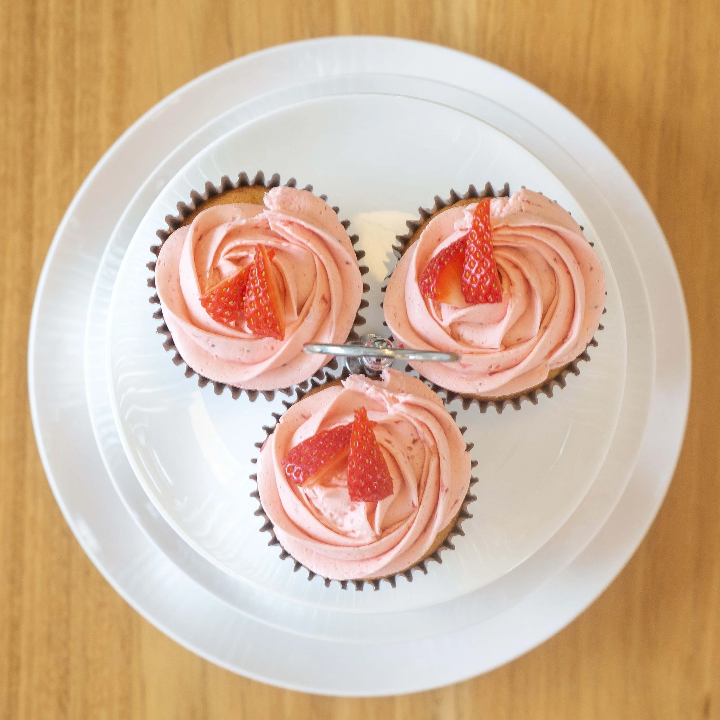 three strawberry cupcakes seen from above