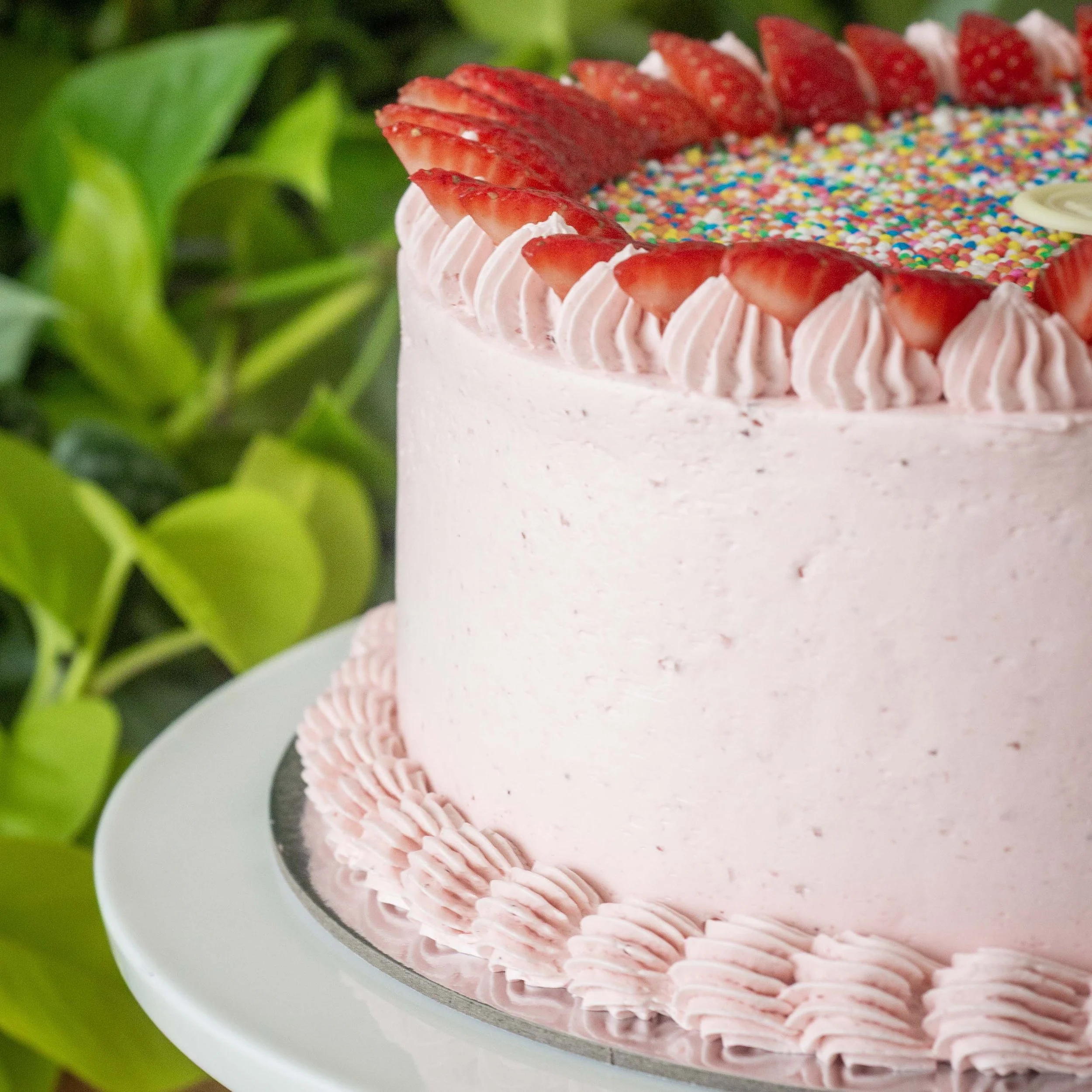 a pink strawberry cake with sprinkles perfect for kids birthday parties