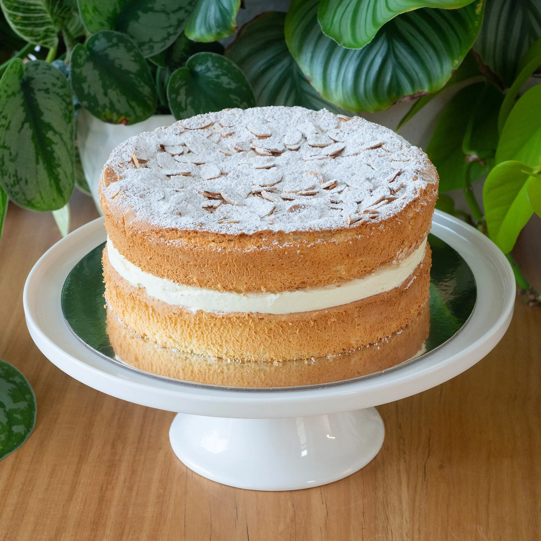 a sponge cake filled with lemon curd and cream and topped with toasted almonds